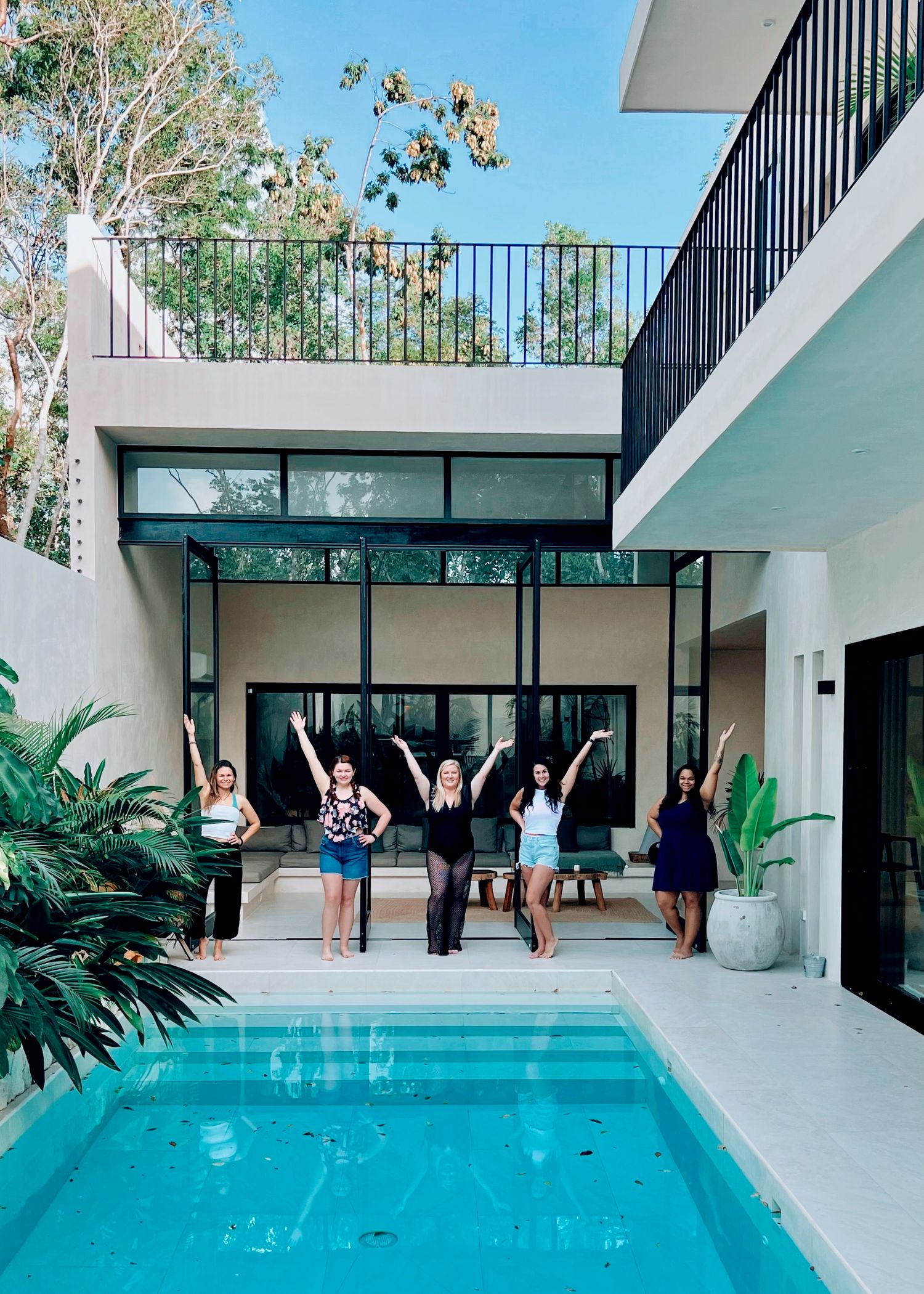 Modern white house with pool and celebrating people on the deck.