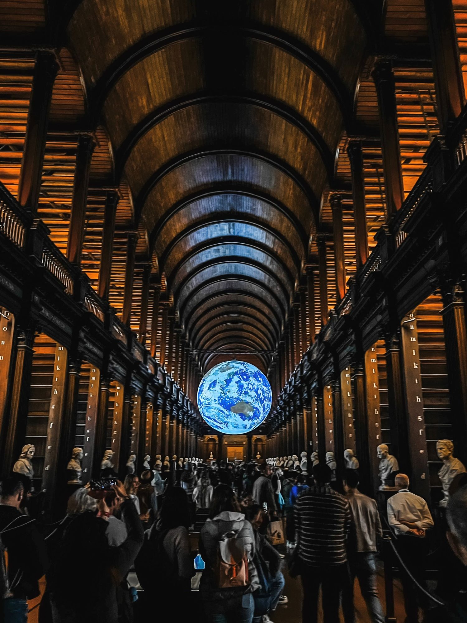 Long corridor with arched ceiling and dramatic lighting leading to illuminated circular window.