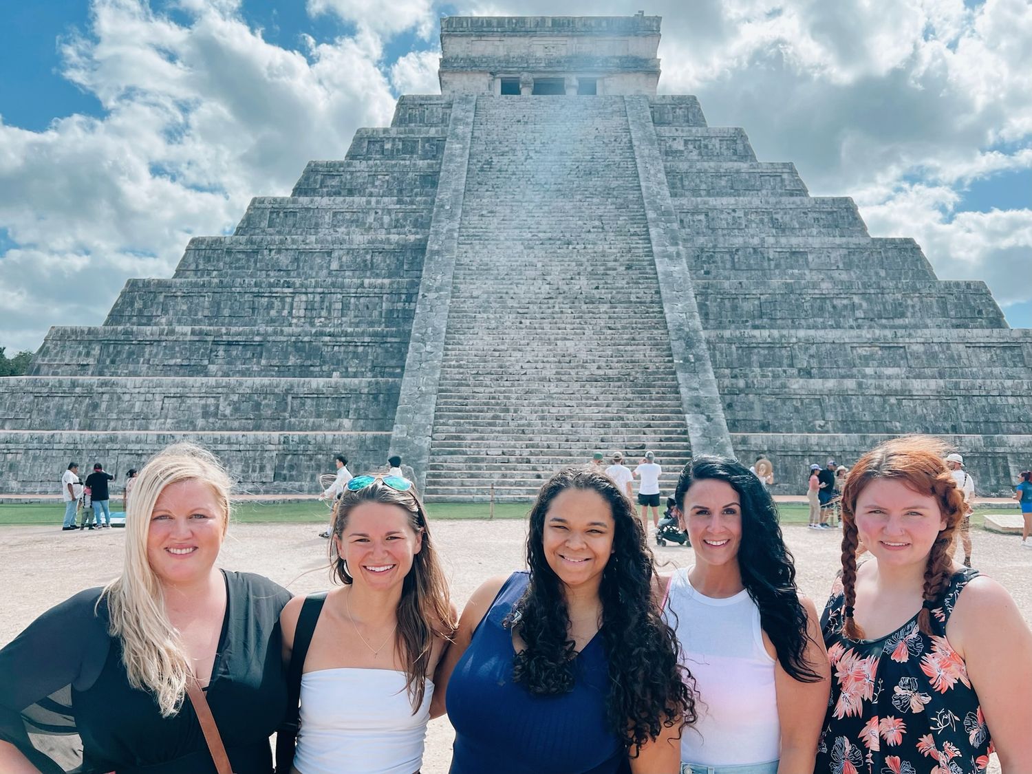 Ancient Mayan pyramid of Chichen Itza rising against cloudy blue sky in Mexico.