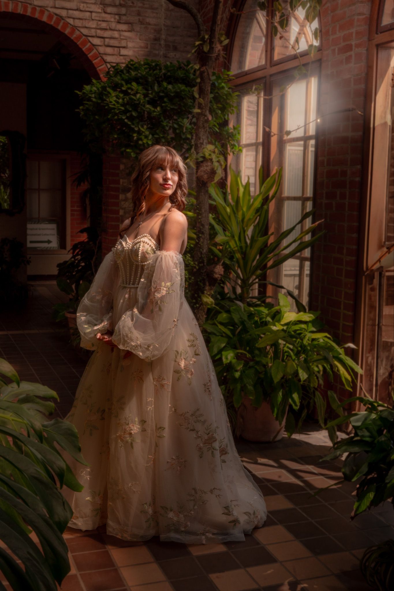 A romantic bridal portrait in a vintage conservatory with soft lighting, checkered floors and lush greenery.