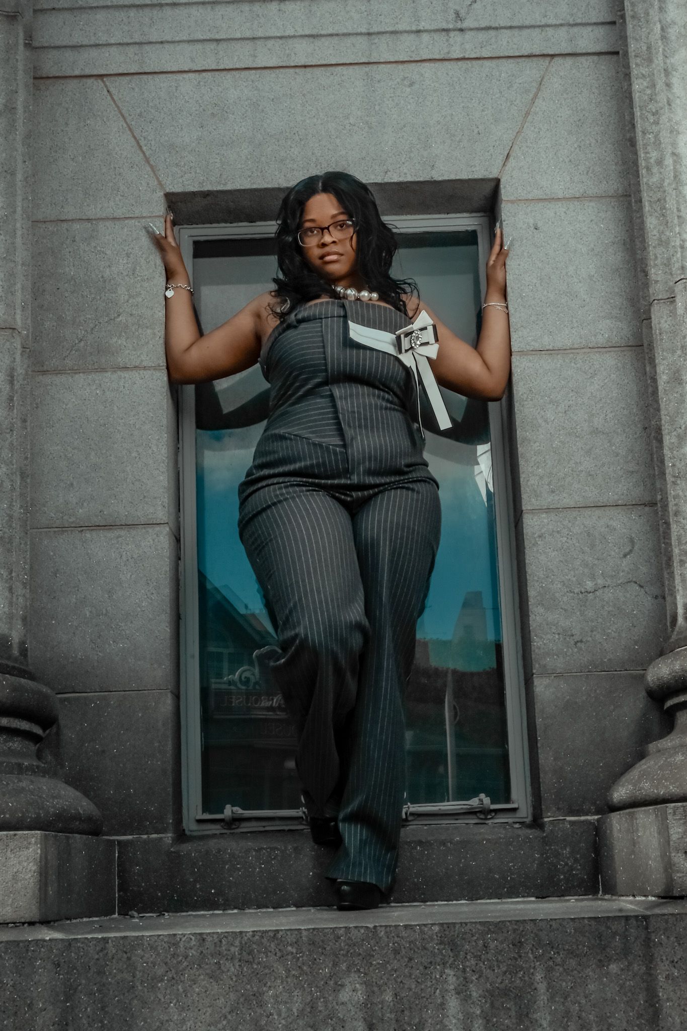 Stylish fashion photography on concrete steps with dramatic architectural elements.