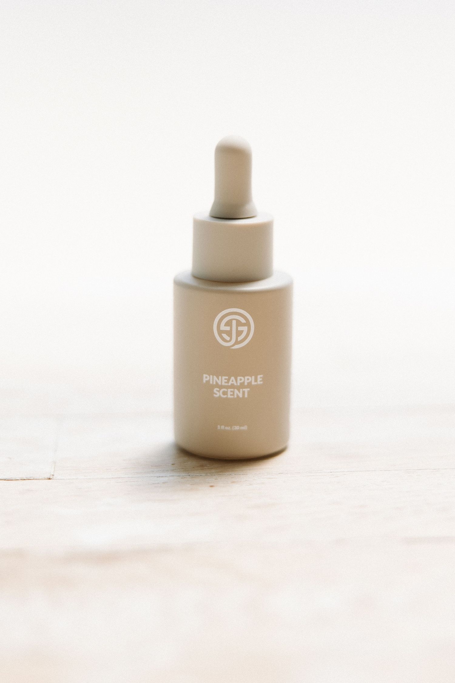 SJOLIE Pineapple Scent dropper bottle photographed on light wooden surface.