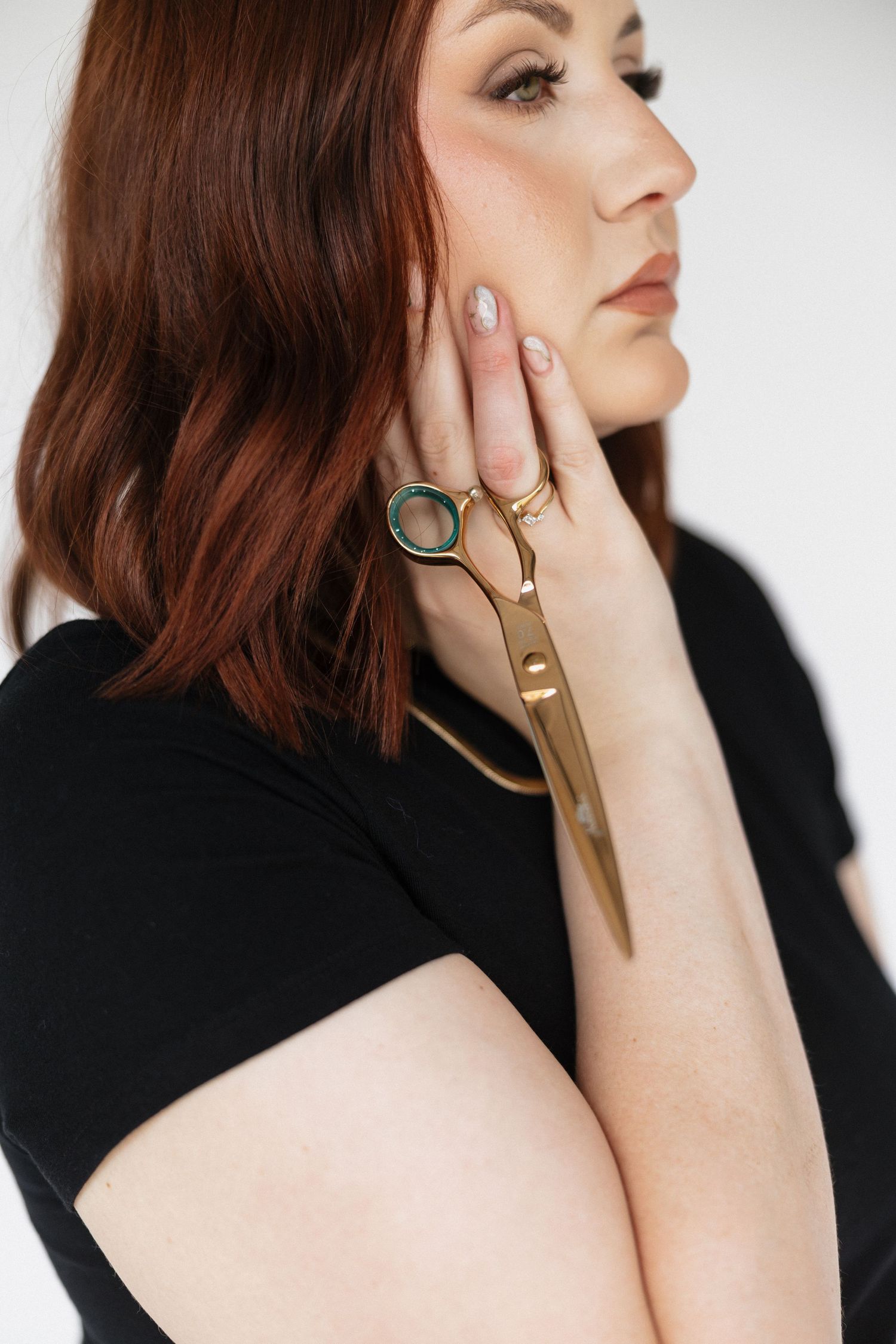 Close-up portrait showcasing geometric gold jewelry and accessories.