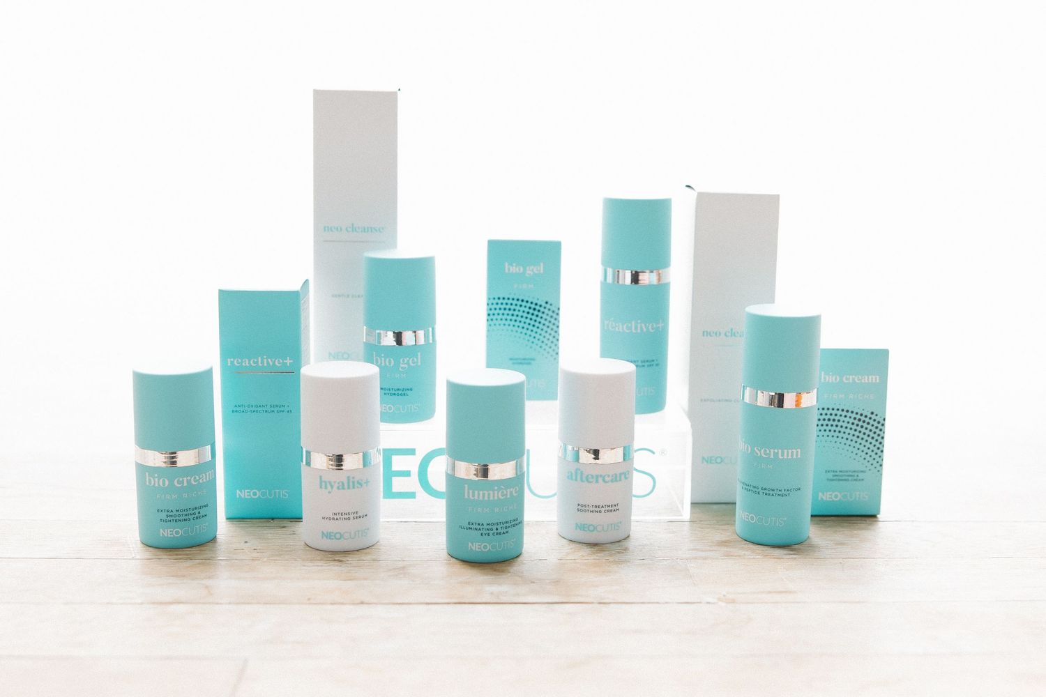 Row of turquoise and white beauty product containers displayed on light surface.