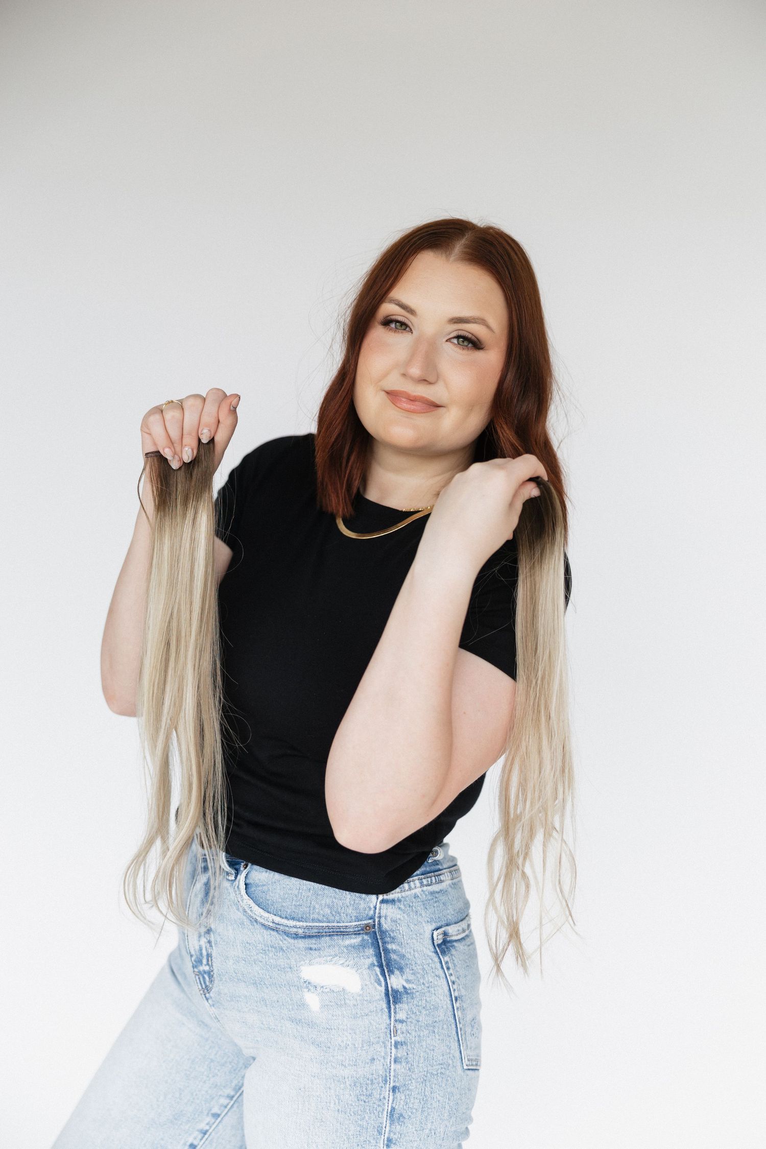 Fashion portrait demonstrating blonde hair extensions with casual black top.