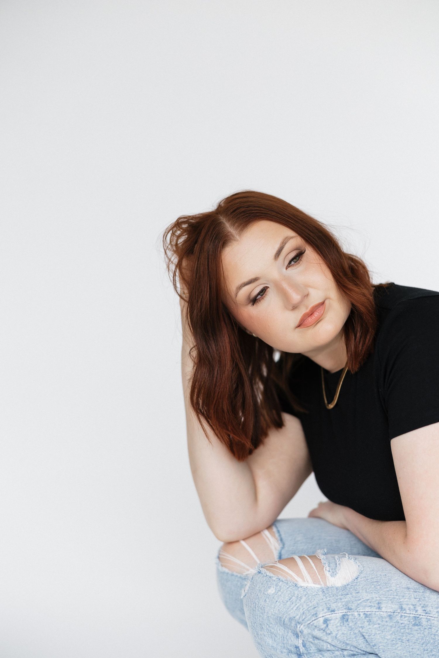 Studio fashion portraits with natural makeup and styling against white backdrop.