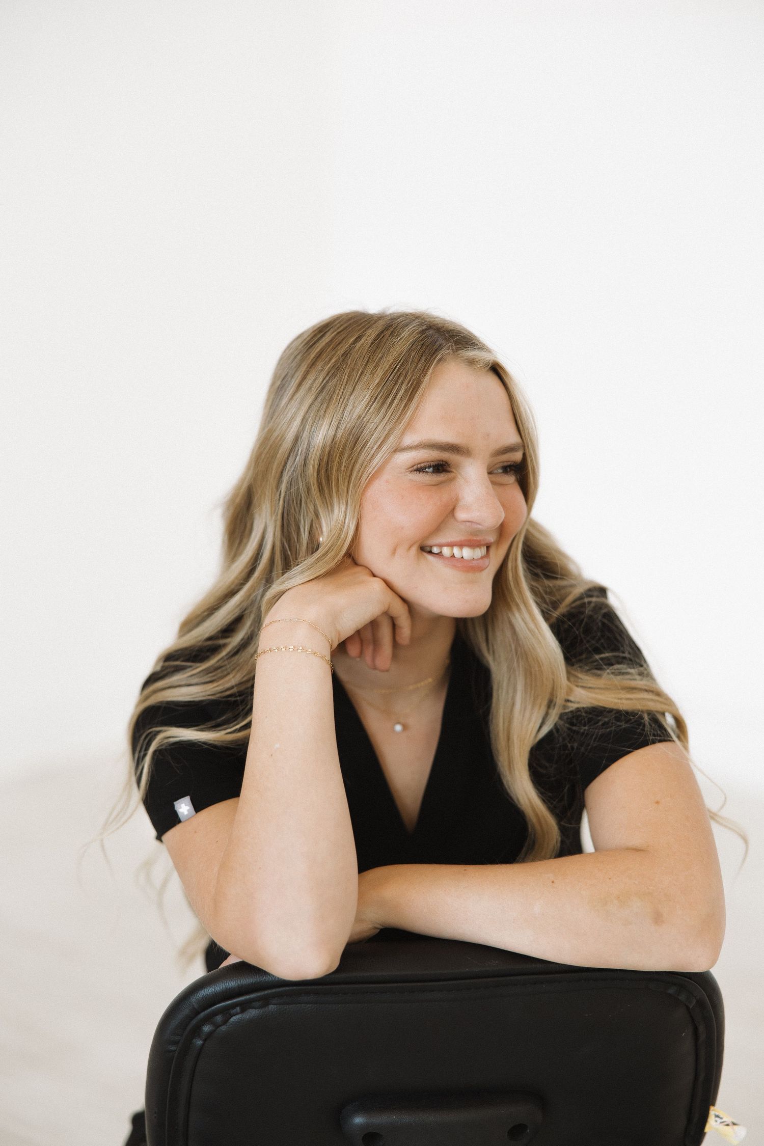 Person resting on office chair with relaxed expression in studio setting.