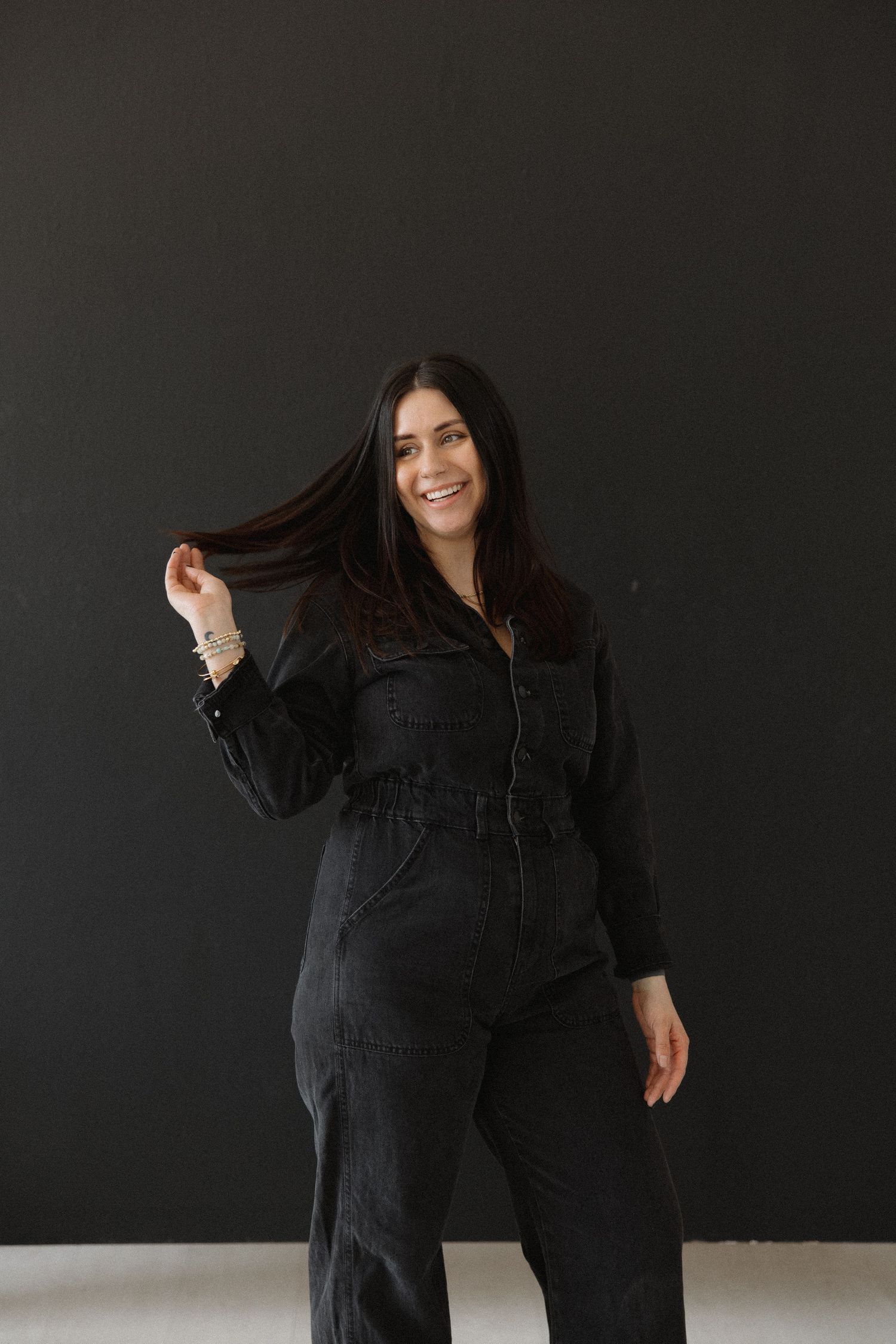 Figure in black denim creates dynamic movement poses against dark background.