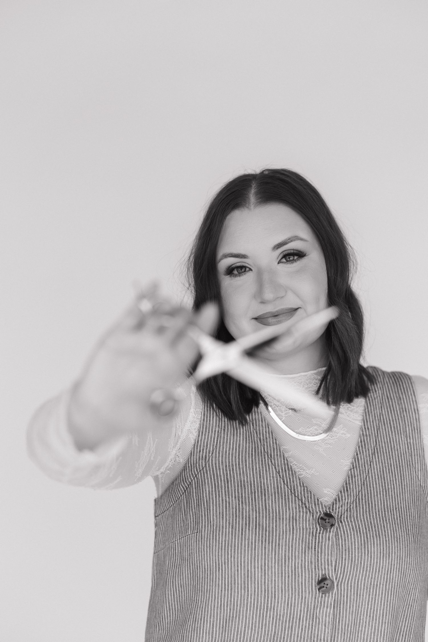 Black and white portrait showing playful poses in a striped vest and white top.