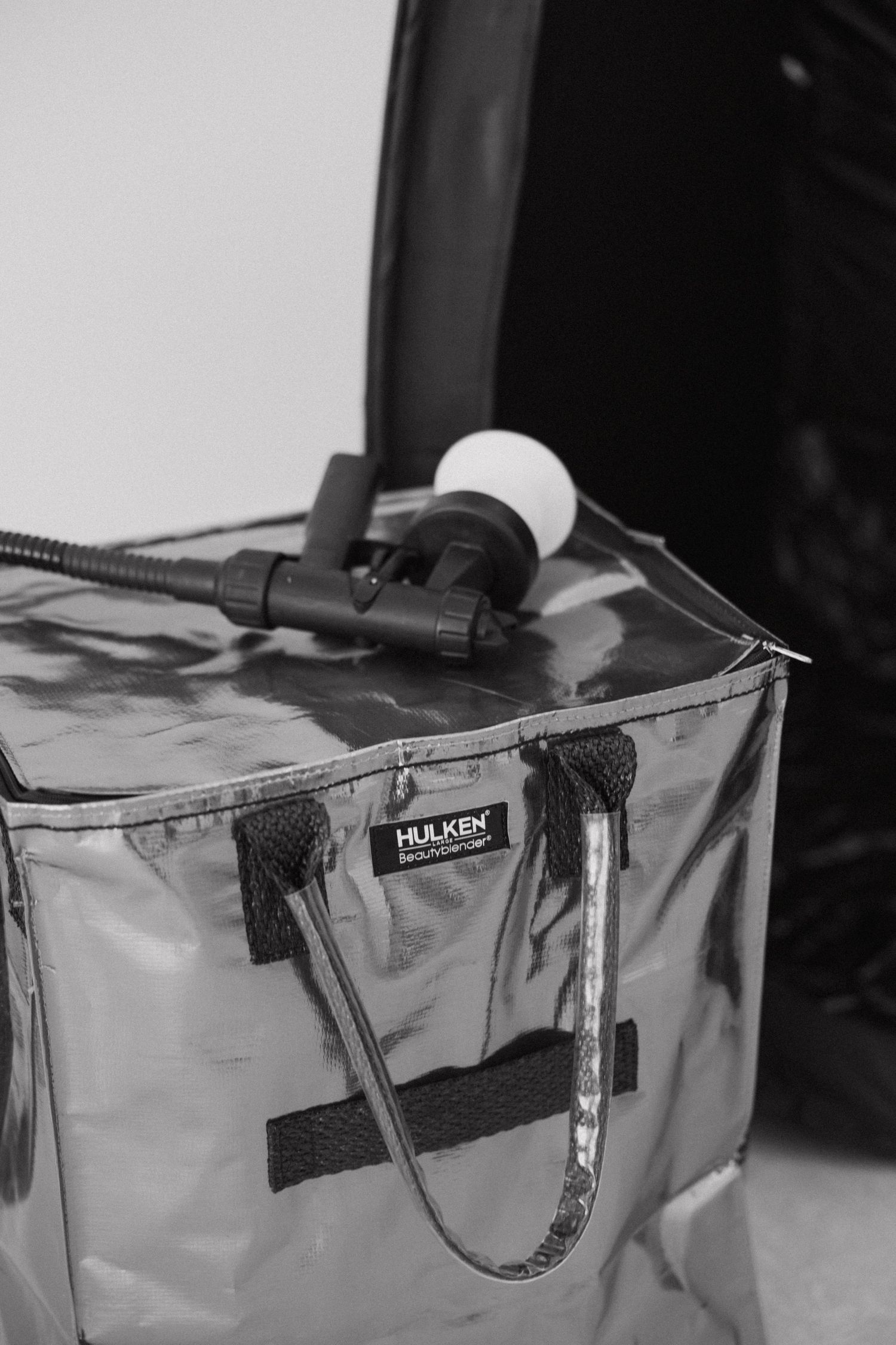 Clear plastic storage bag with black straps and spray nozzle visible on top.