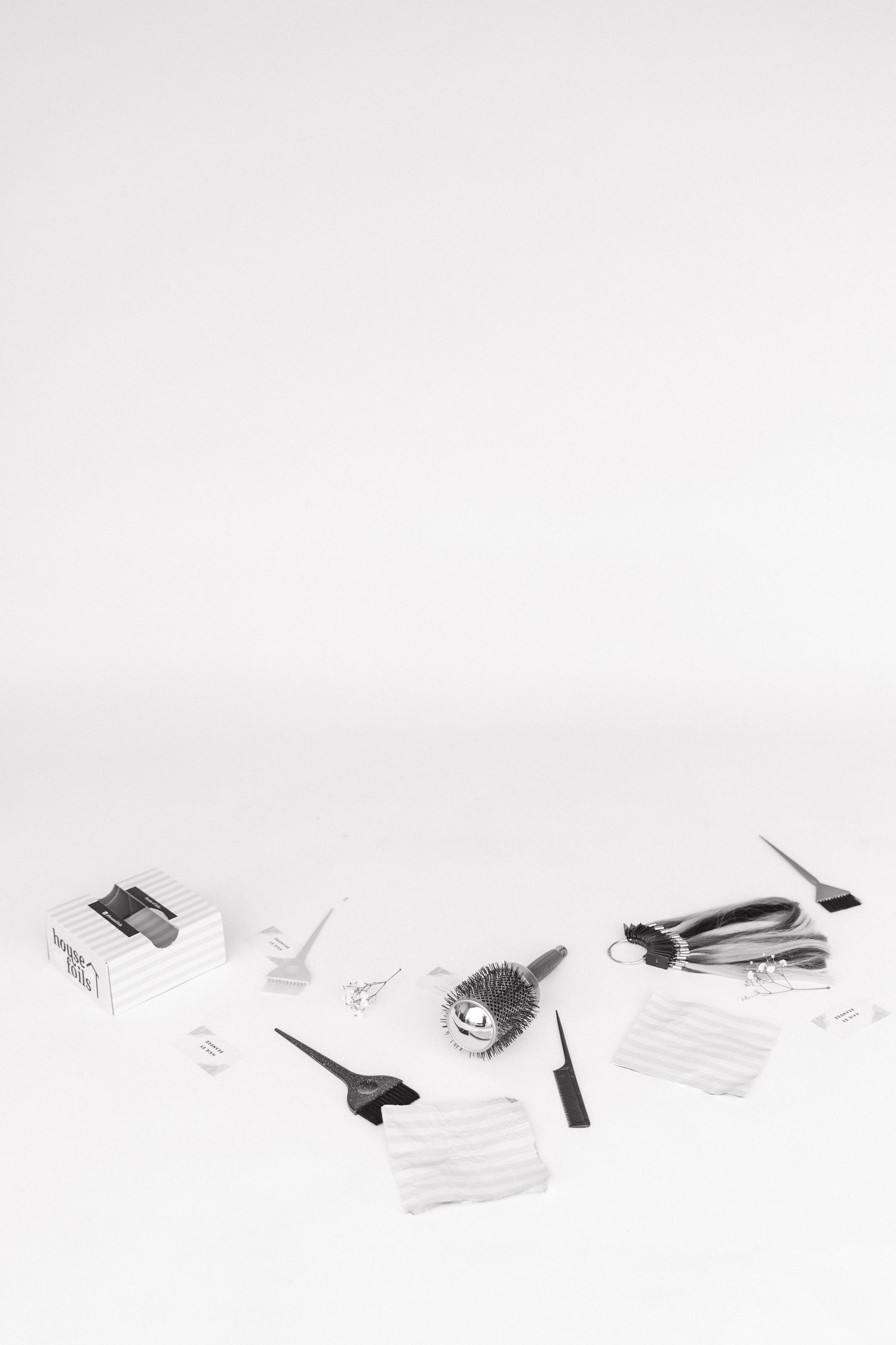 Minimalist black and white still life of beauty hair tools and hair foils.