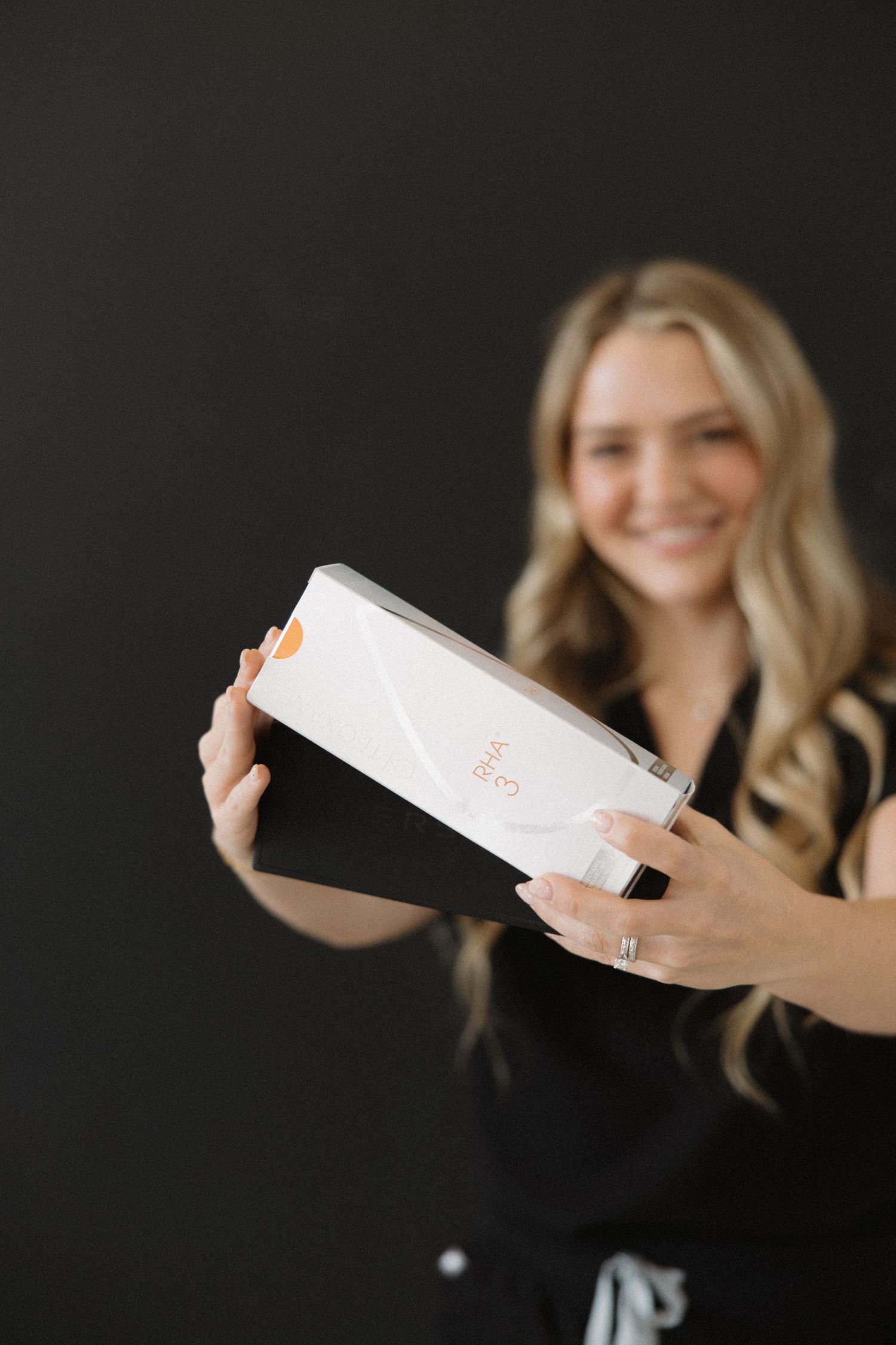 Professional in medical attire demonstrates white product packaging.