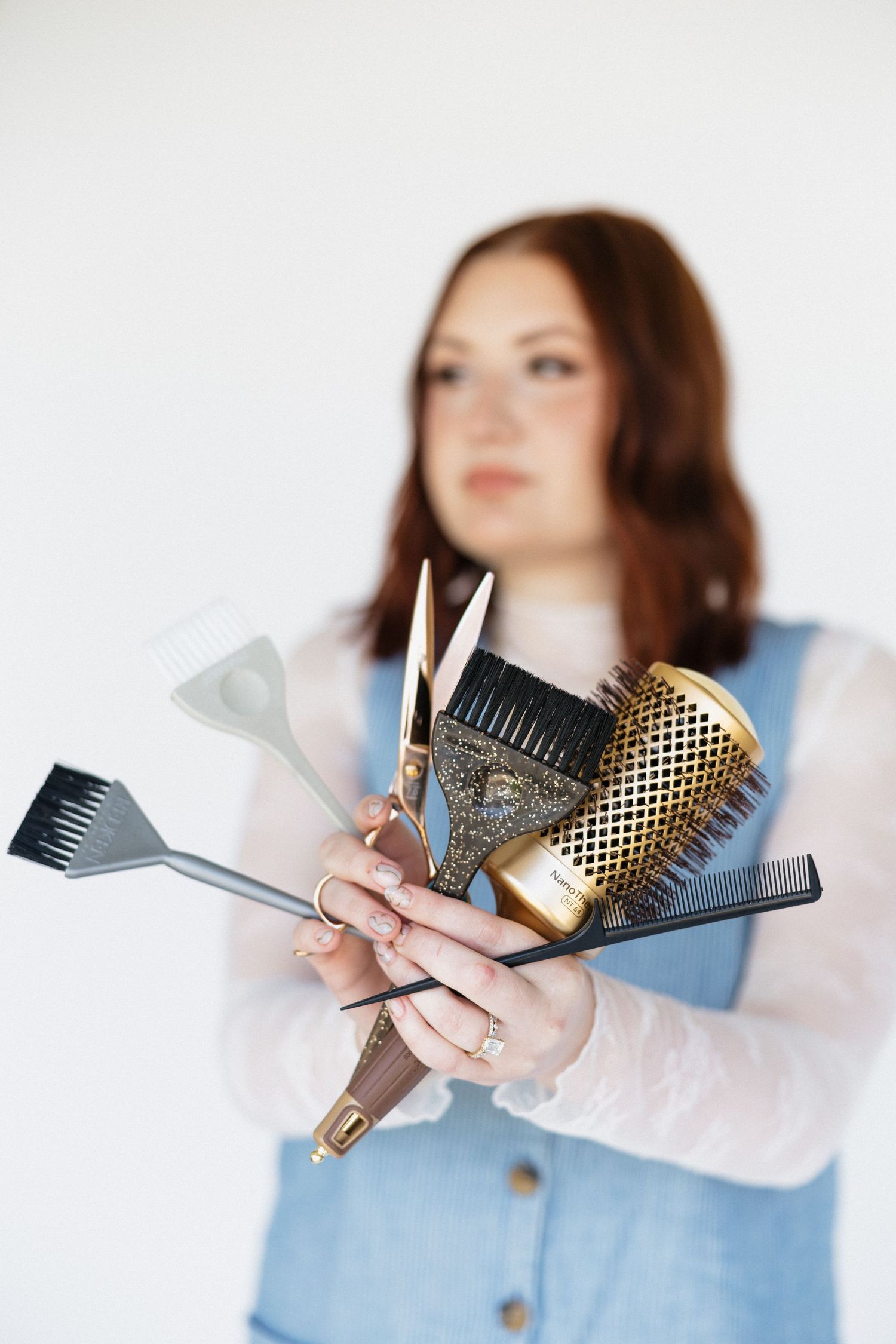 Professional hair styling tools arranged in fan pattern held against white background.