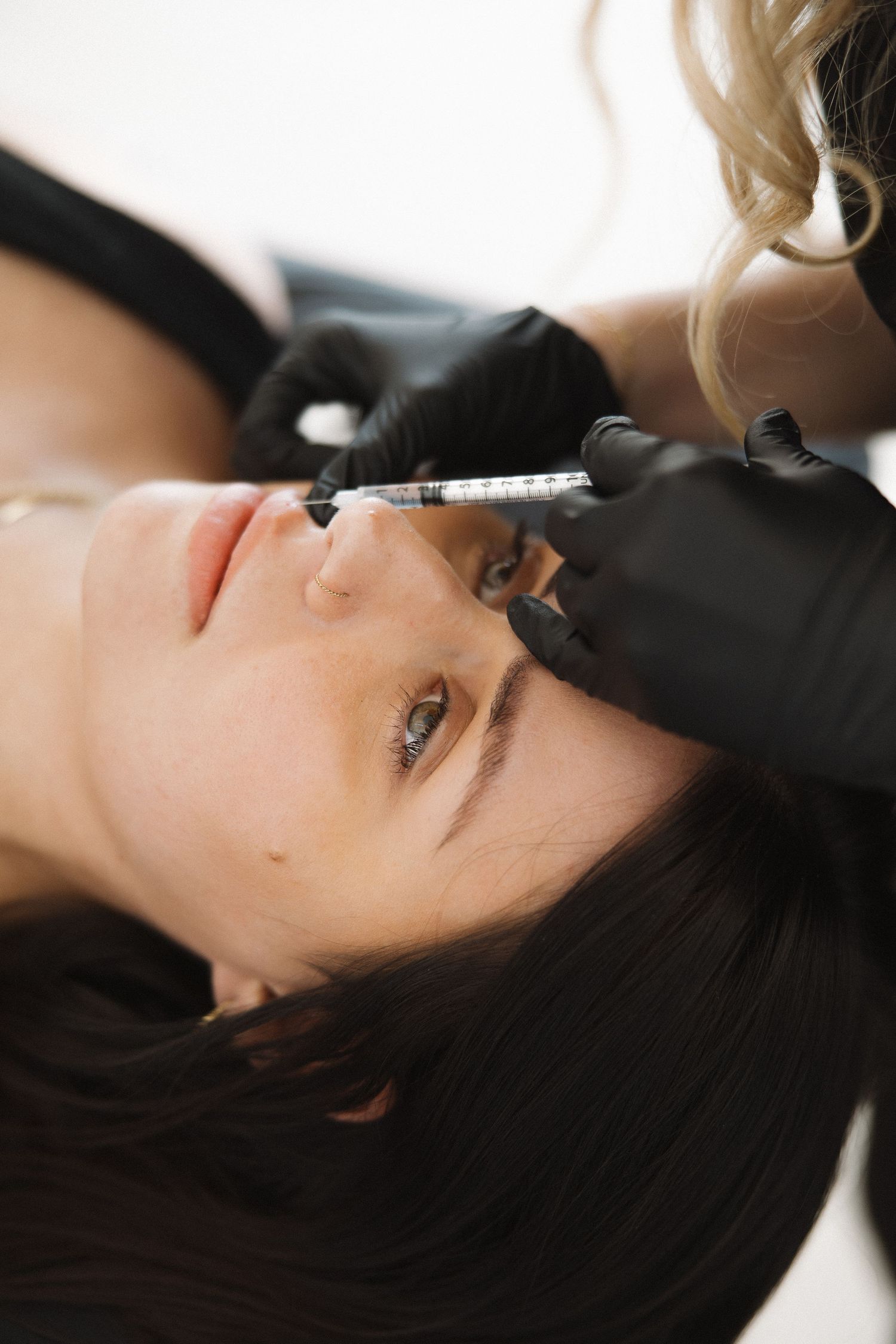 Side view of cosmetic treatment being administered in professional setting.