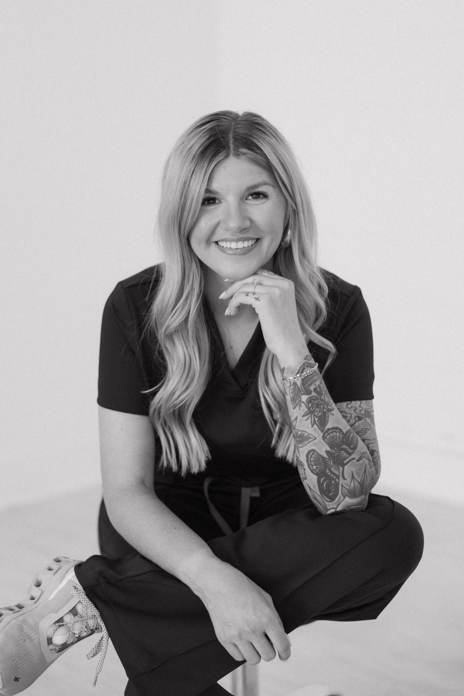 Black and white portrait showing casual style and tattoo art.