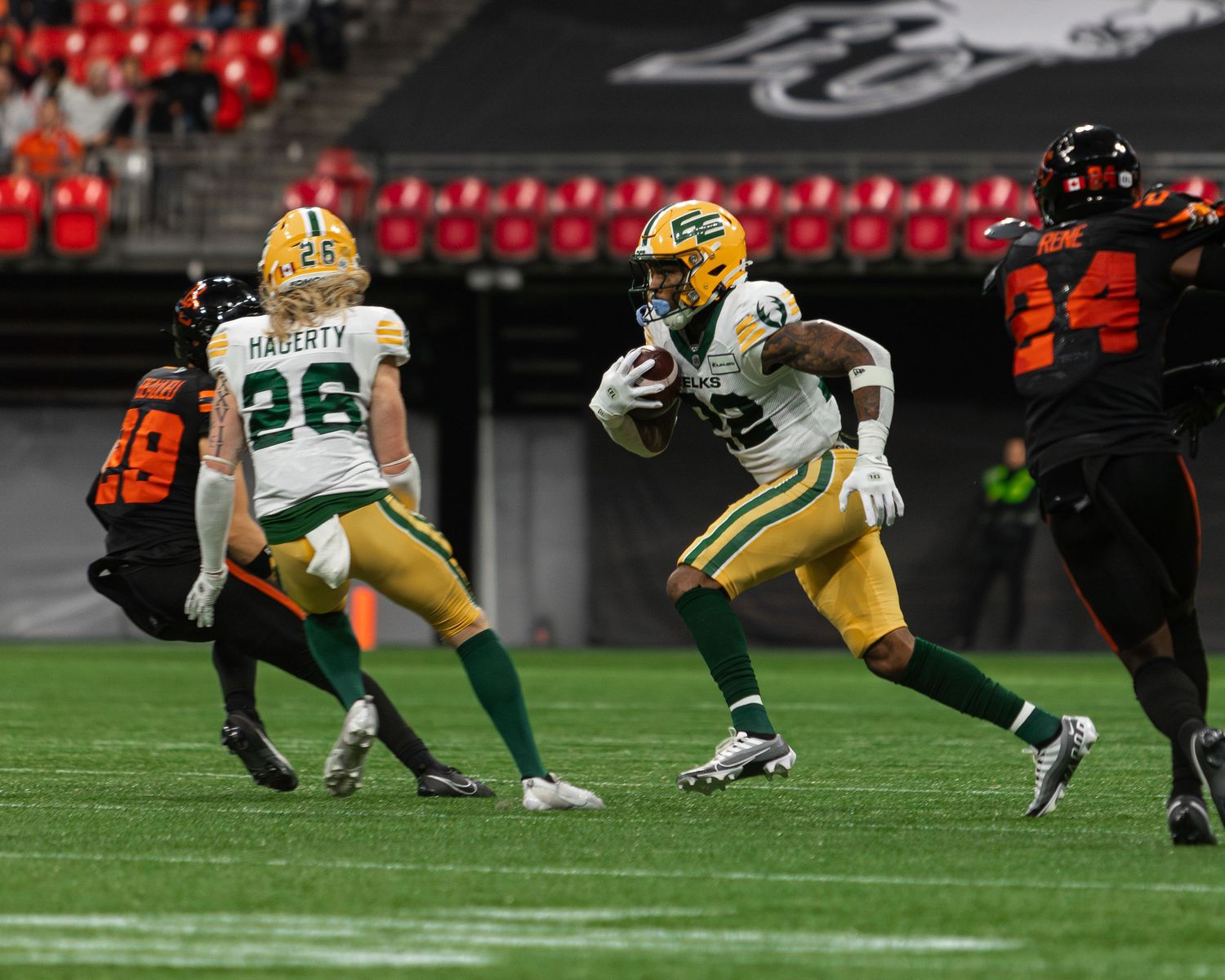 Edmonton Elks player runs with football during CFL game against BC Lions at BC Place stadium.