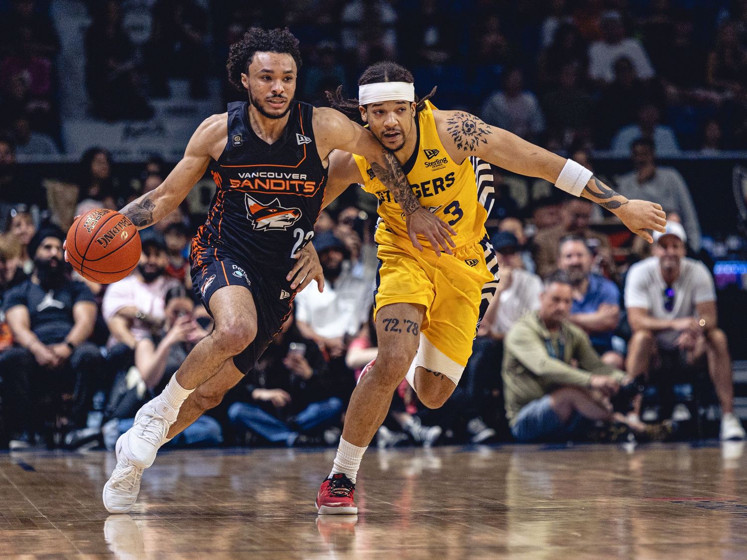 Two basketball players compete as one dribbles past a defender during a professional league game.