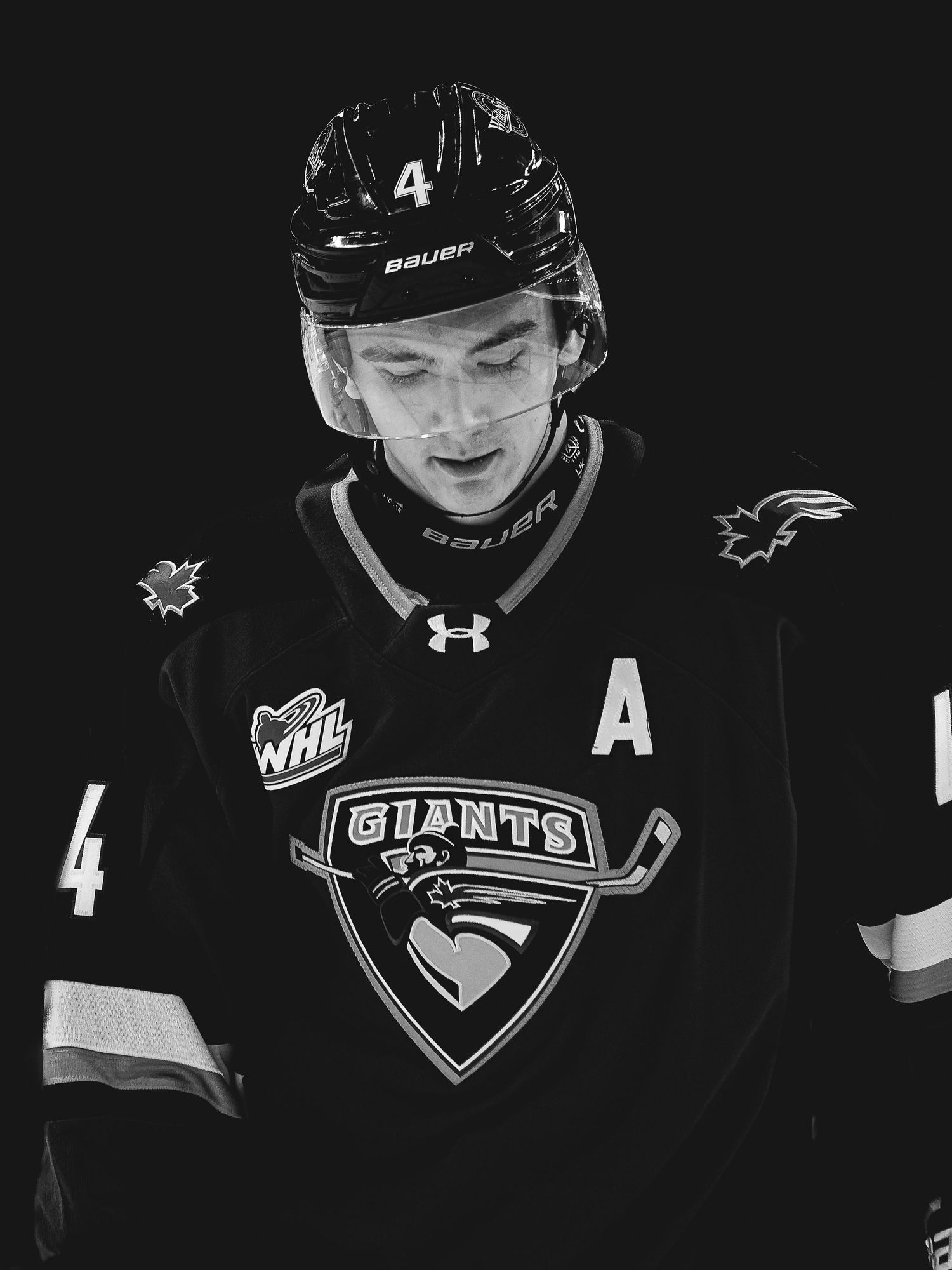 Black and white photo of a hockey player wearing a Vancouver Giants WHL jersey with number 4 and an A for alternate captain.