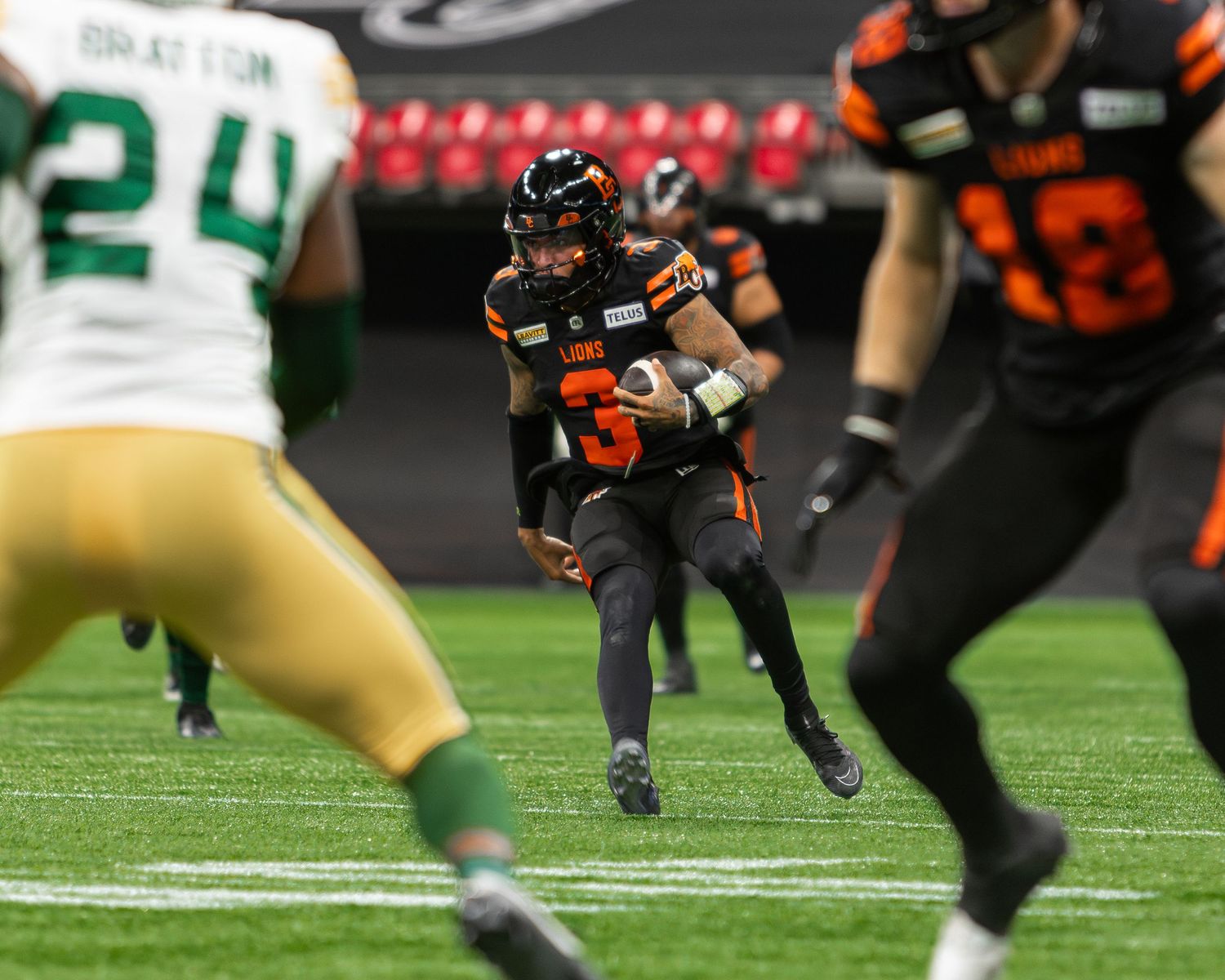 BC Lions quarterback scrambles with the ball during a CFL game against the Edmonton Elks at BC Place Stadium.