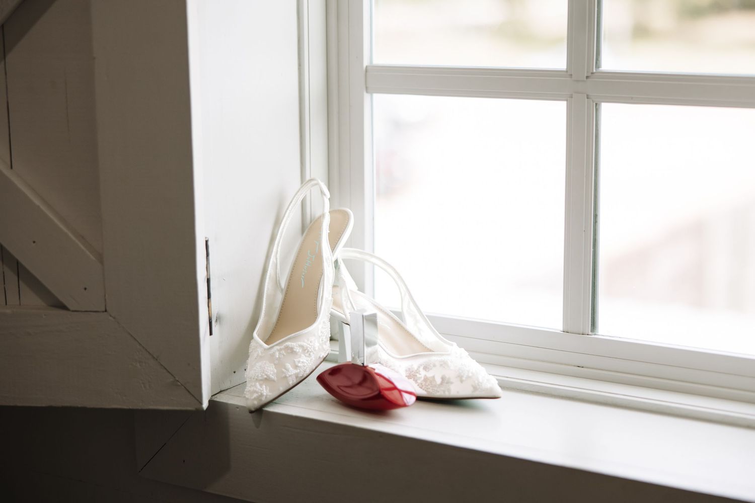 White ceramic coffee mugs sit on a windowsill, creating a minimalist and serene kitchen scene in natural light.