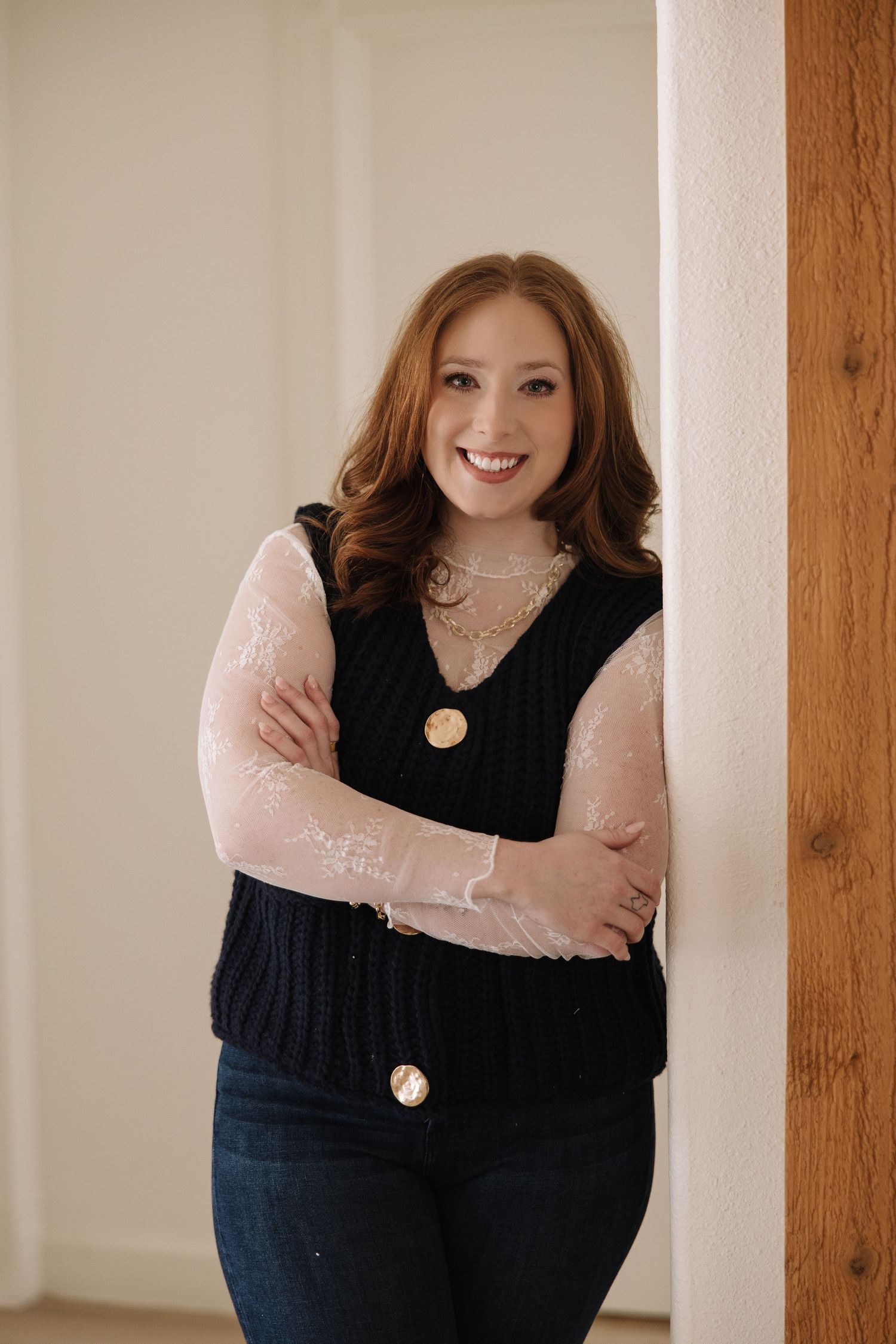 A series of casual indoor portraits showing someone wearing a black sweater and pink top against a light wall with wood beams.