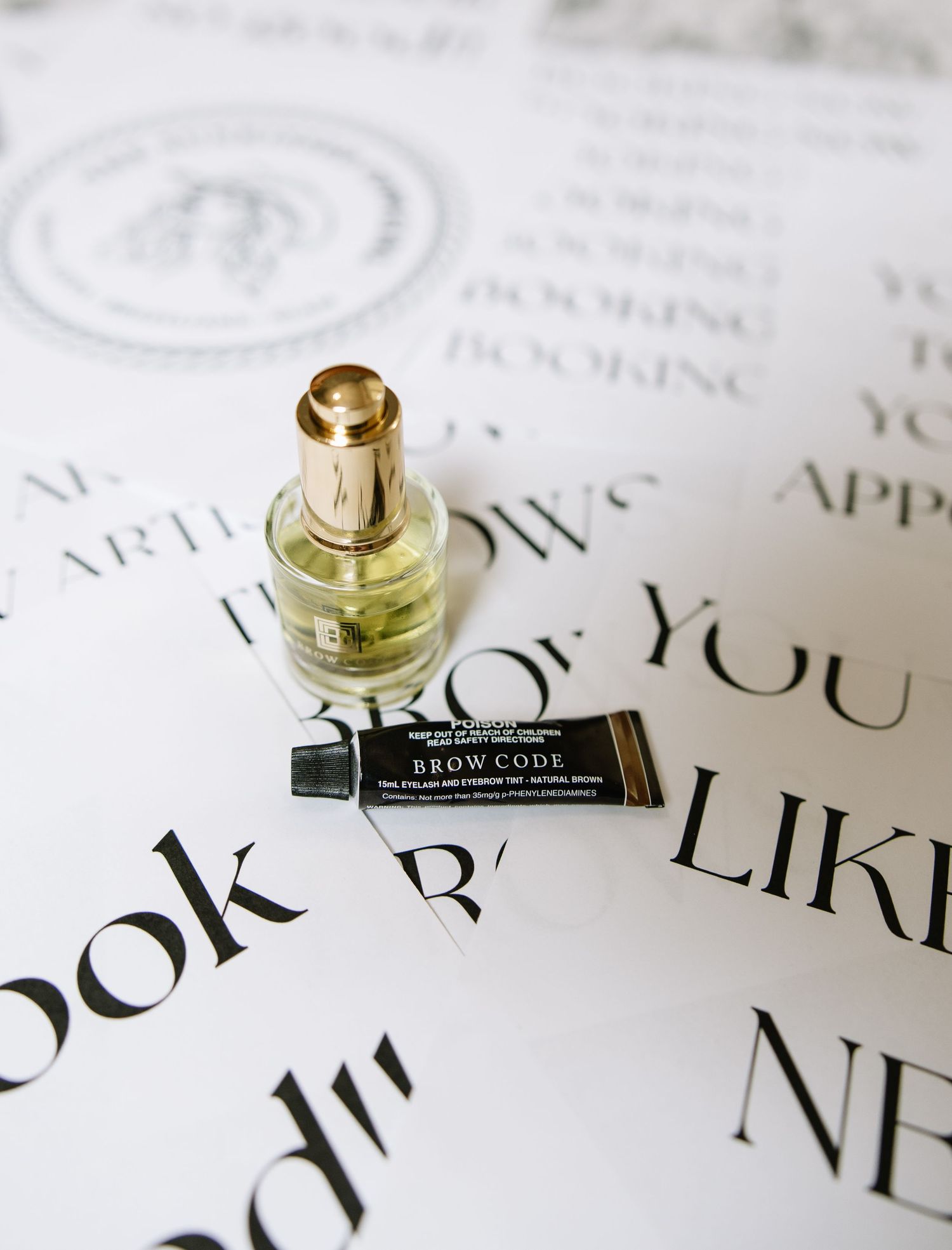 Close-up of perfume bottles and elegant typography on white paper.
