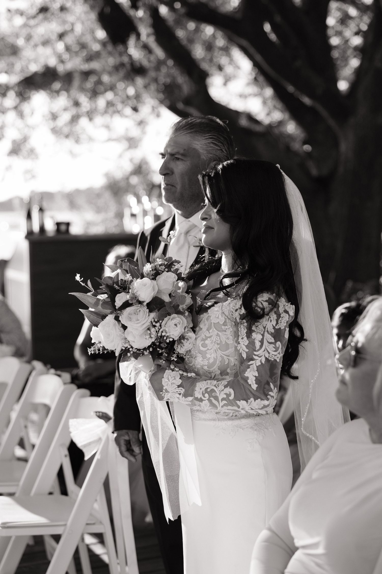 Black and white wedding photos show couple embracing with white floral bouquet during outdoor ceremony.