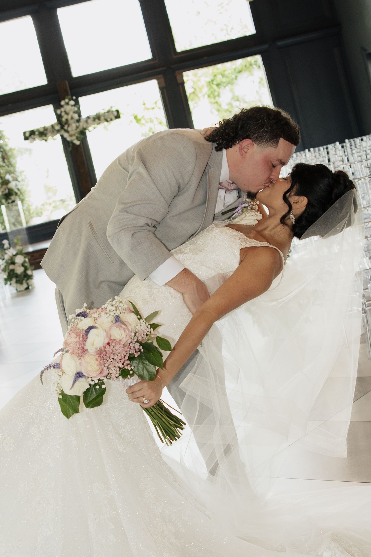 Romantic wedding couple shares an intimate moment during their first look in a bright indoor setting.