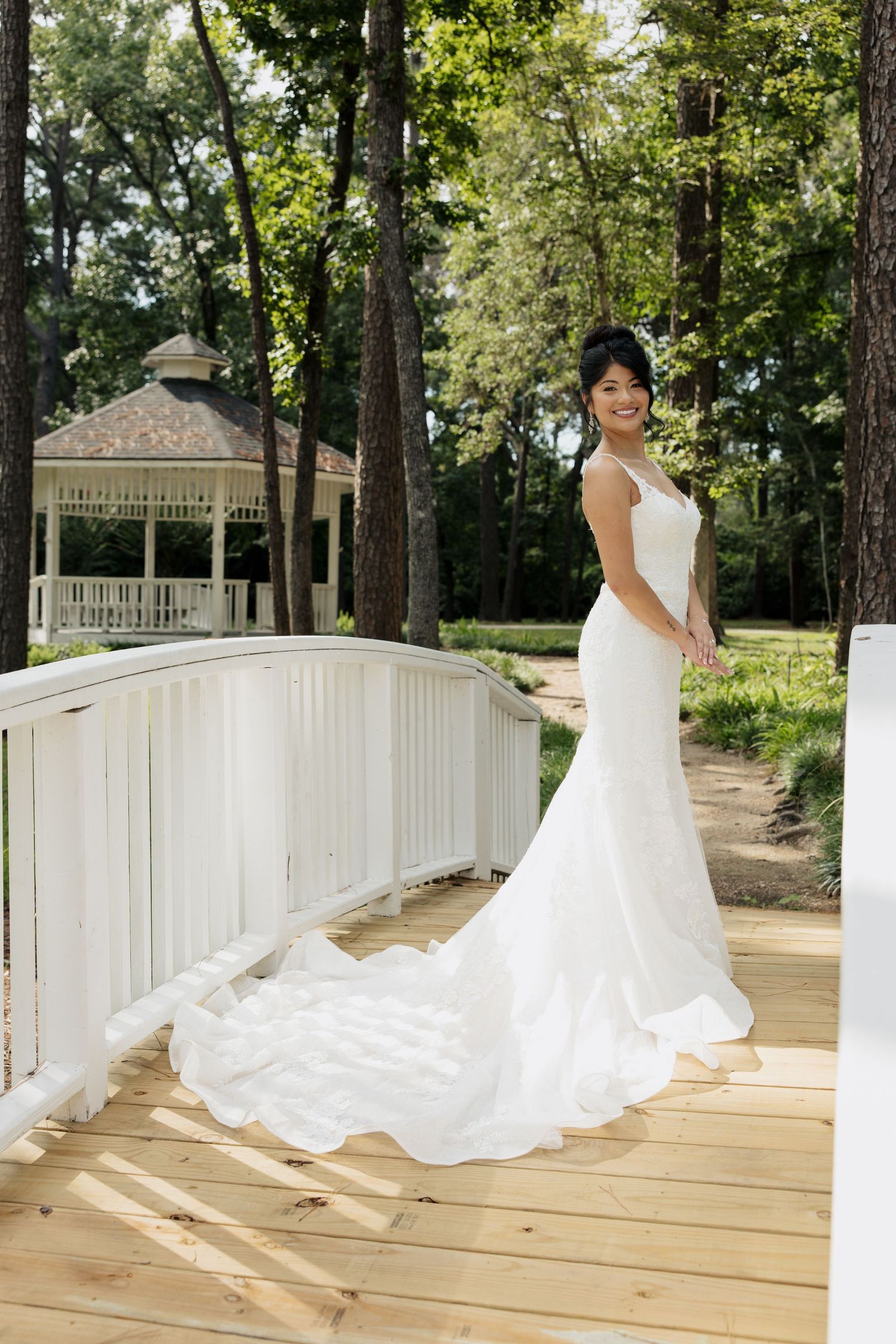 Beautiful bridal portrait on a white wooden bridge with a gazebo in the background.