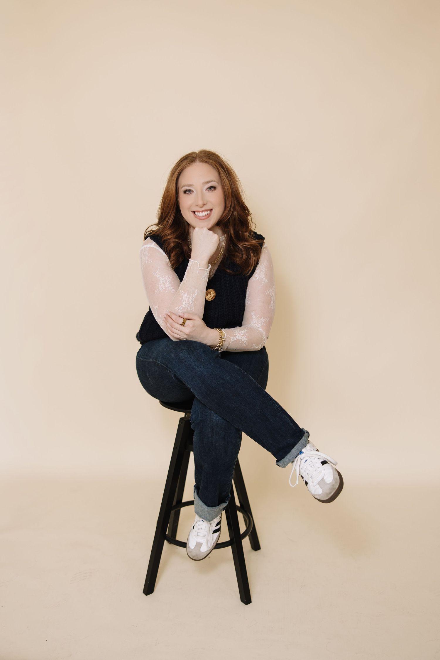A series of casual portrait shots sitting on a black stool against a beige wall.
