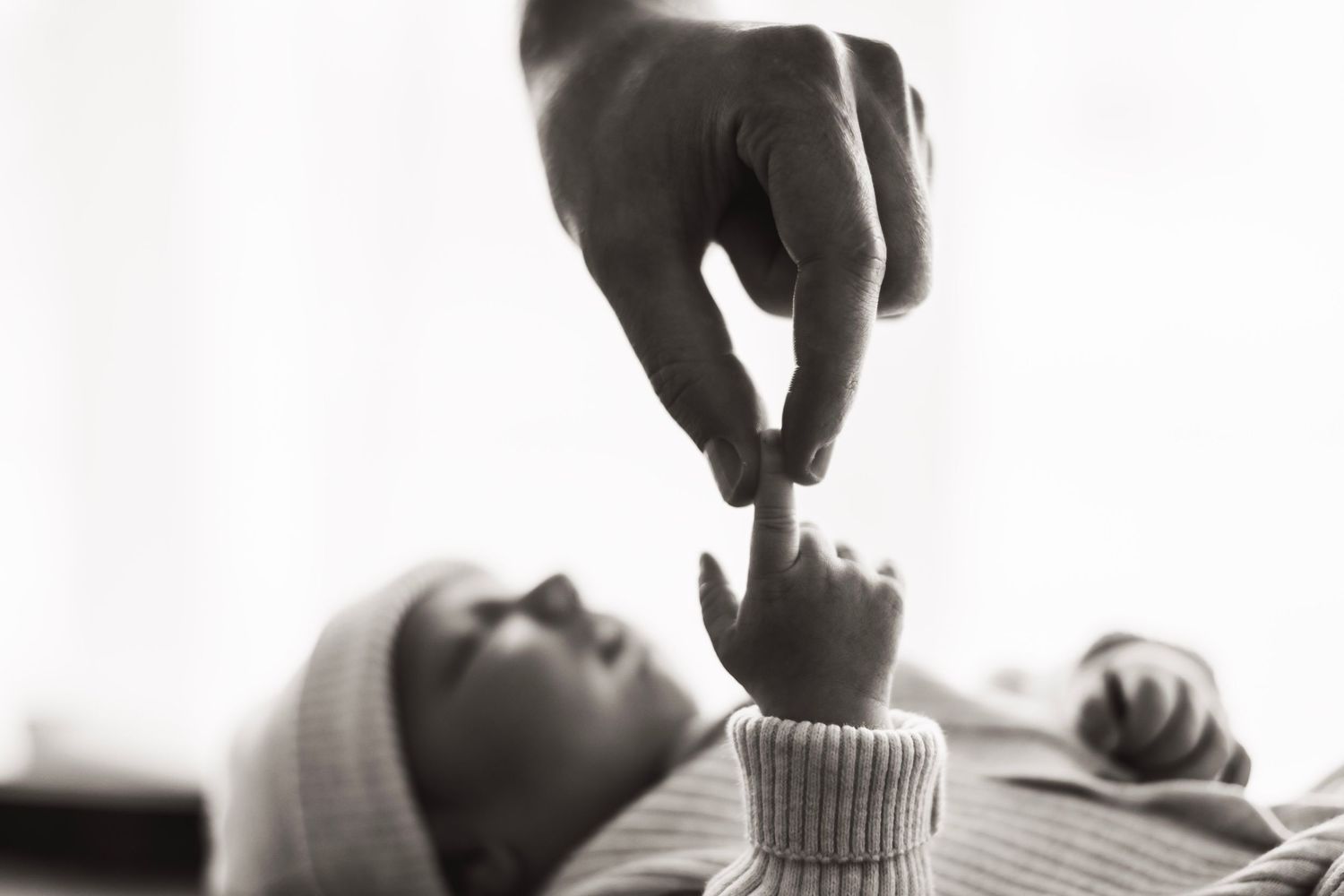 Black and white photo of a father and his newborn child.