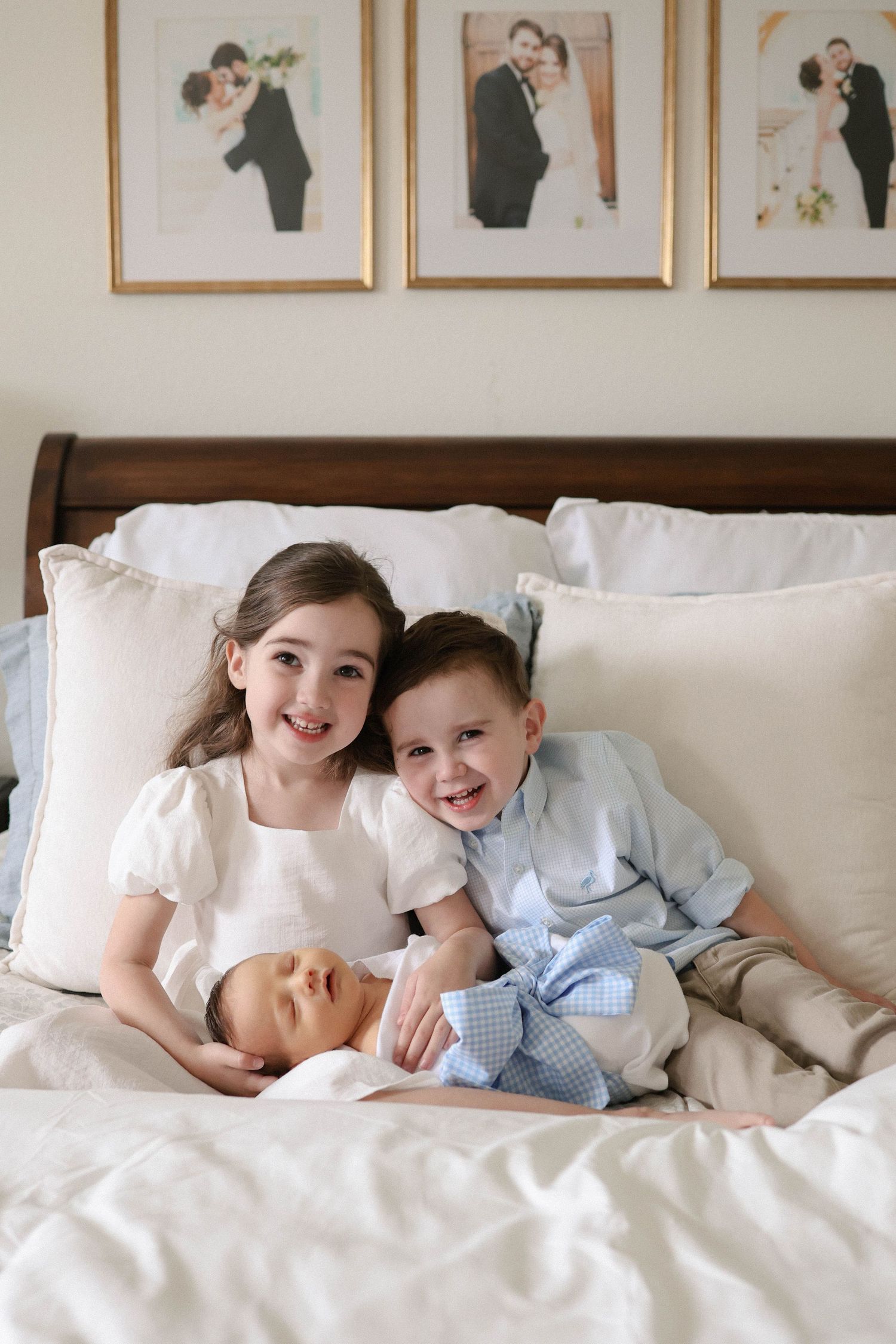 Children in white clothing share joyful moments while relaxing together on a cozy white bed.
