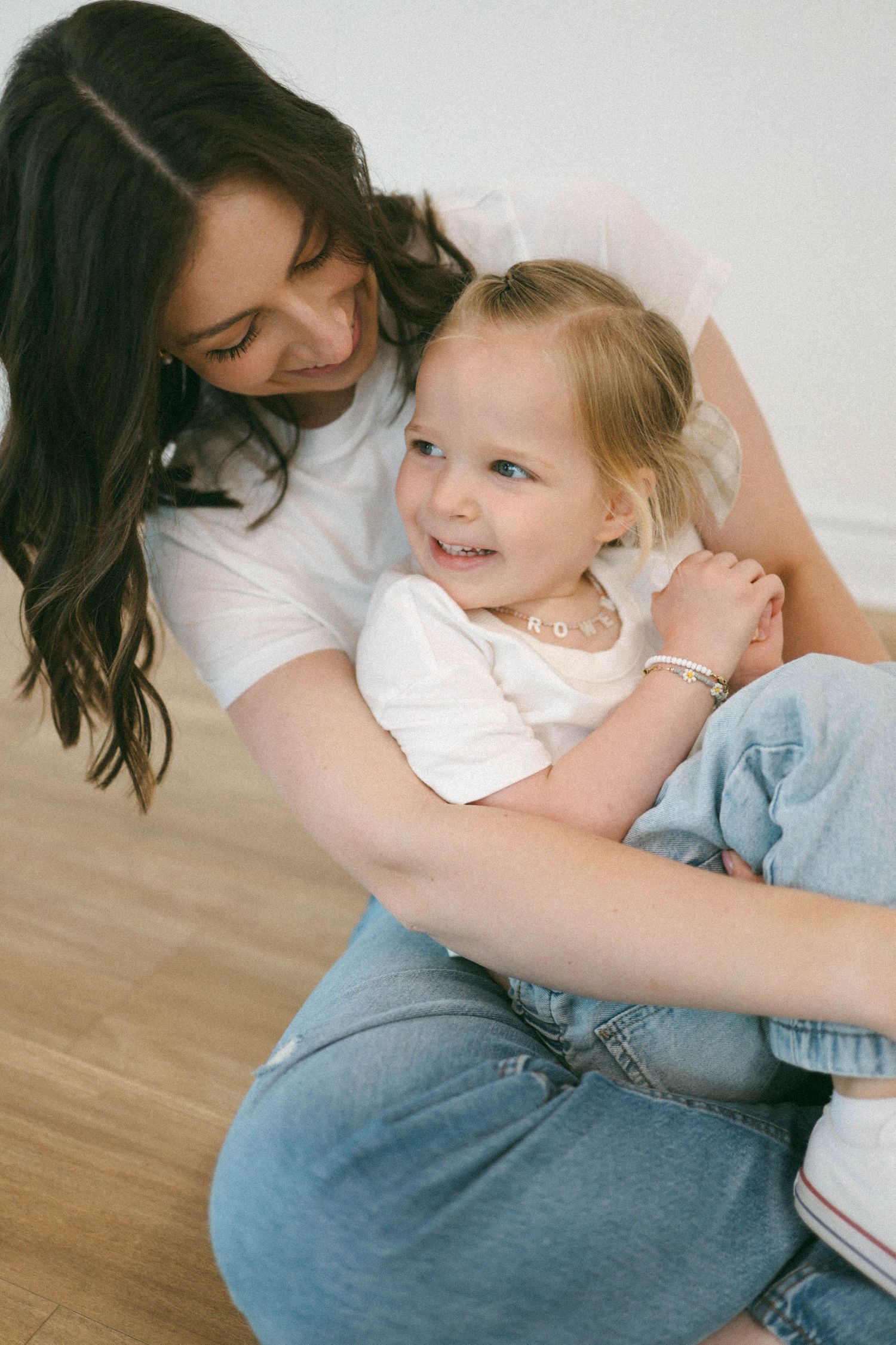 Series showing intimate moments of bonding between parent and child on wooden floor.