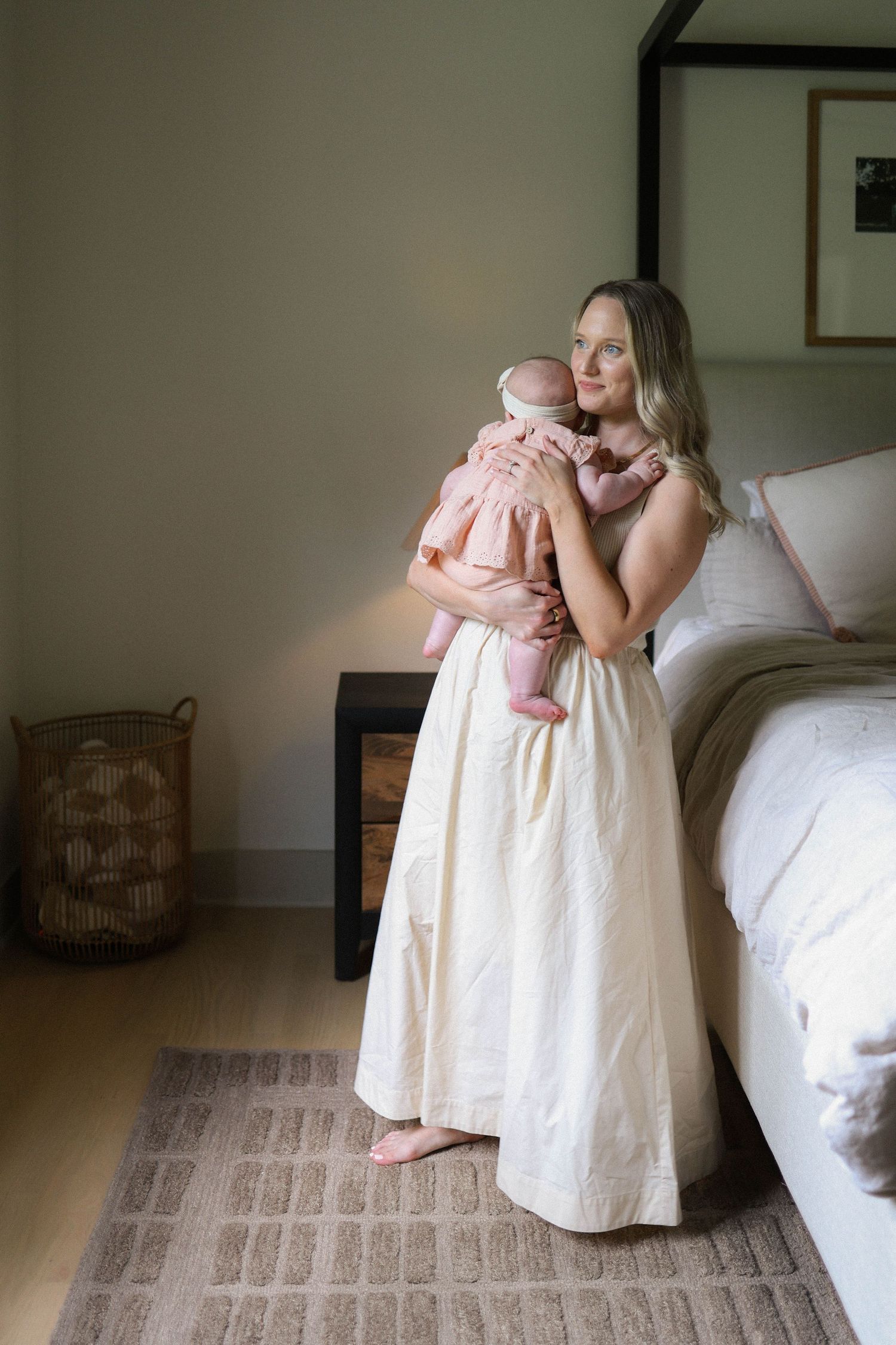 Tender sequence of mama rocking baby in soft natural light during newborn session in home.