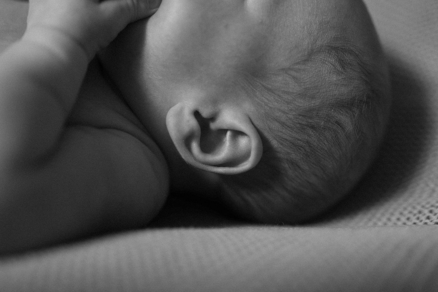 Black and white profile shots of a sleeping newborn baby in peaceful repose.