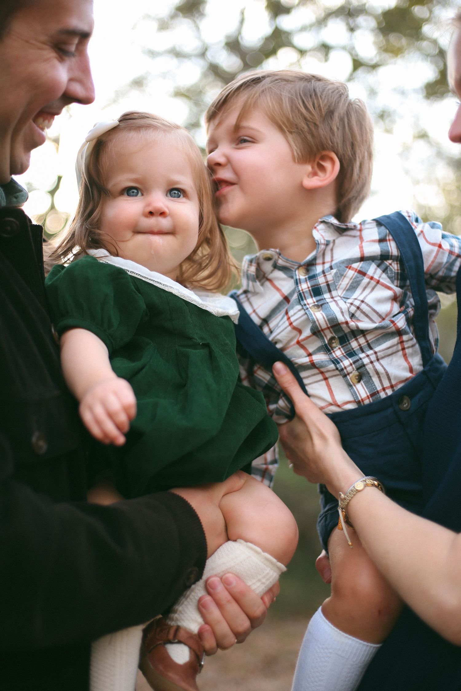 Intimate family moment captured with siblings sharing affectionate interaction.