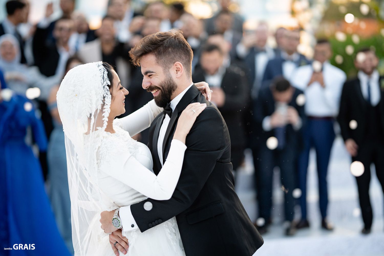 Joyful wedding celebration with guests watching couple's first dance.