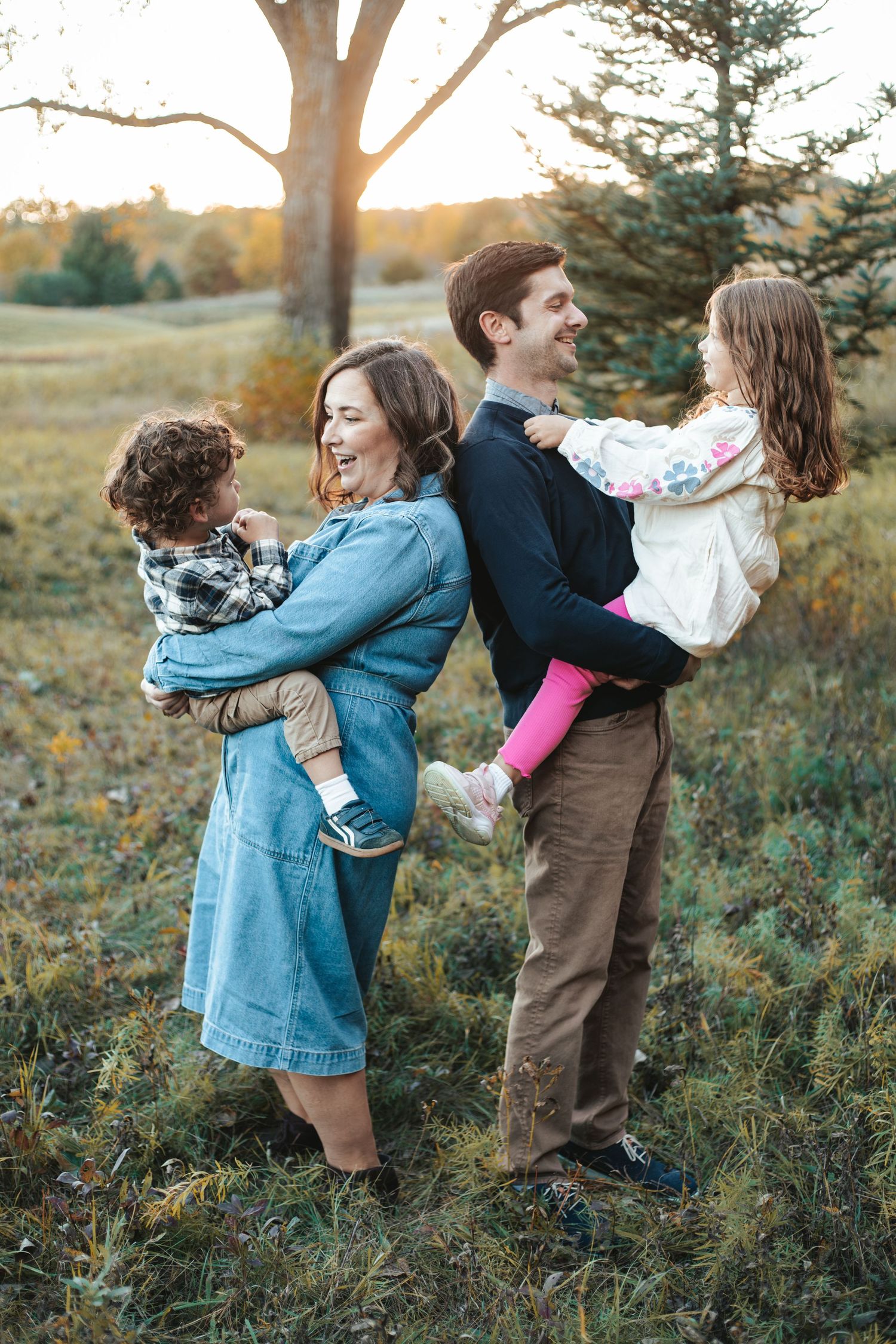 Happy family of four enjoying a golden hour outdoor fall mini session in Lakeville