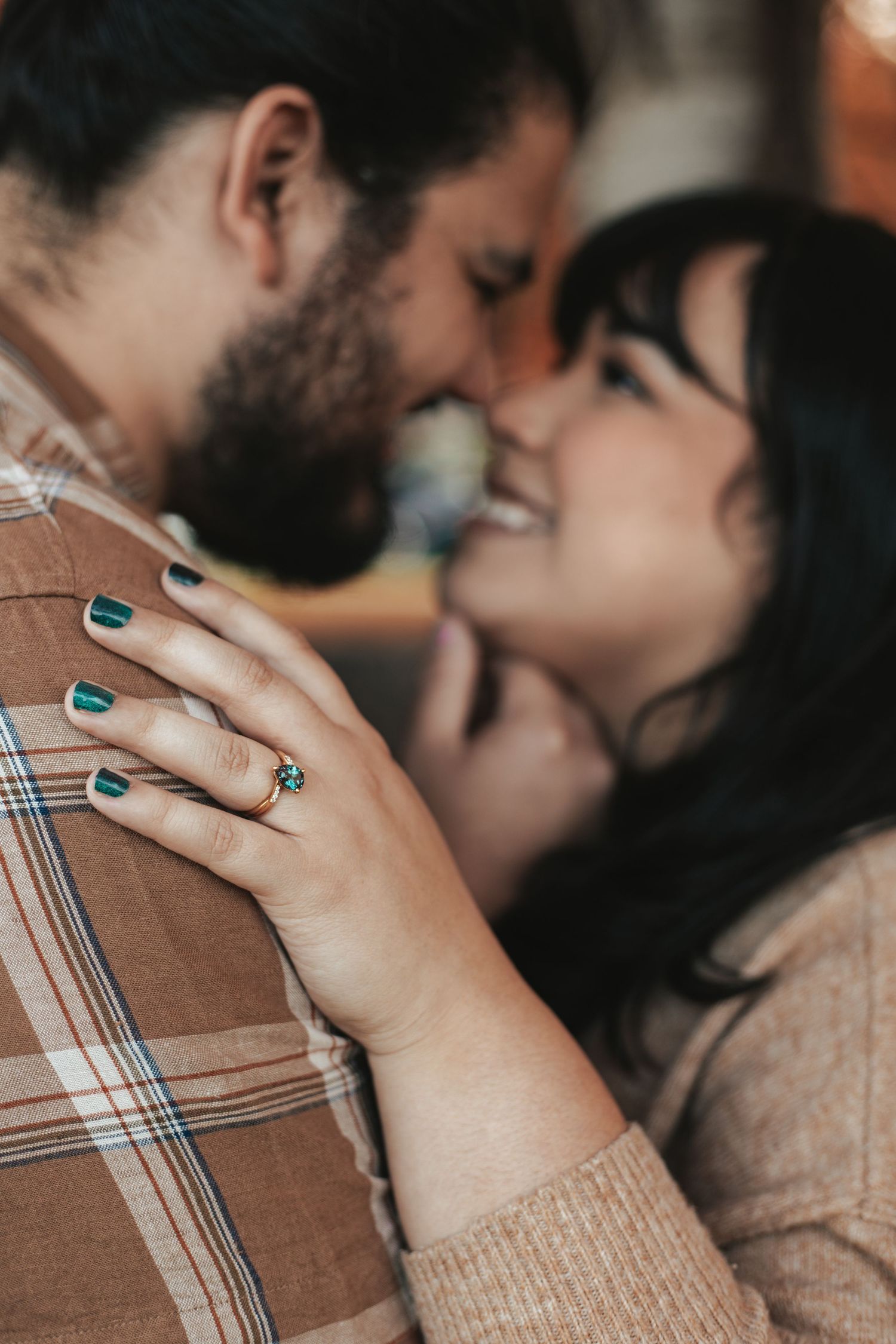 A newly engaged couple embracing in a tender moment, with a ring visible on one person's hand, taken by Woodbury engagement photographer.