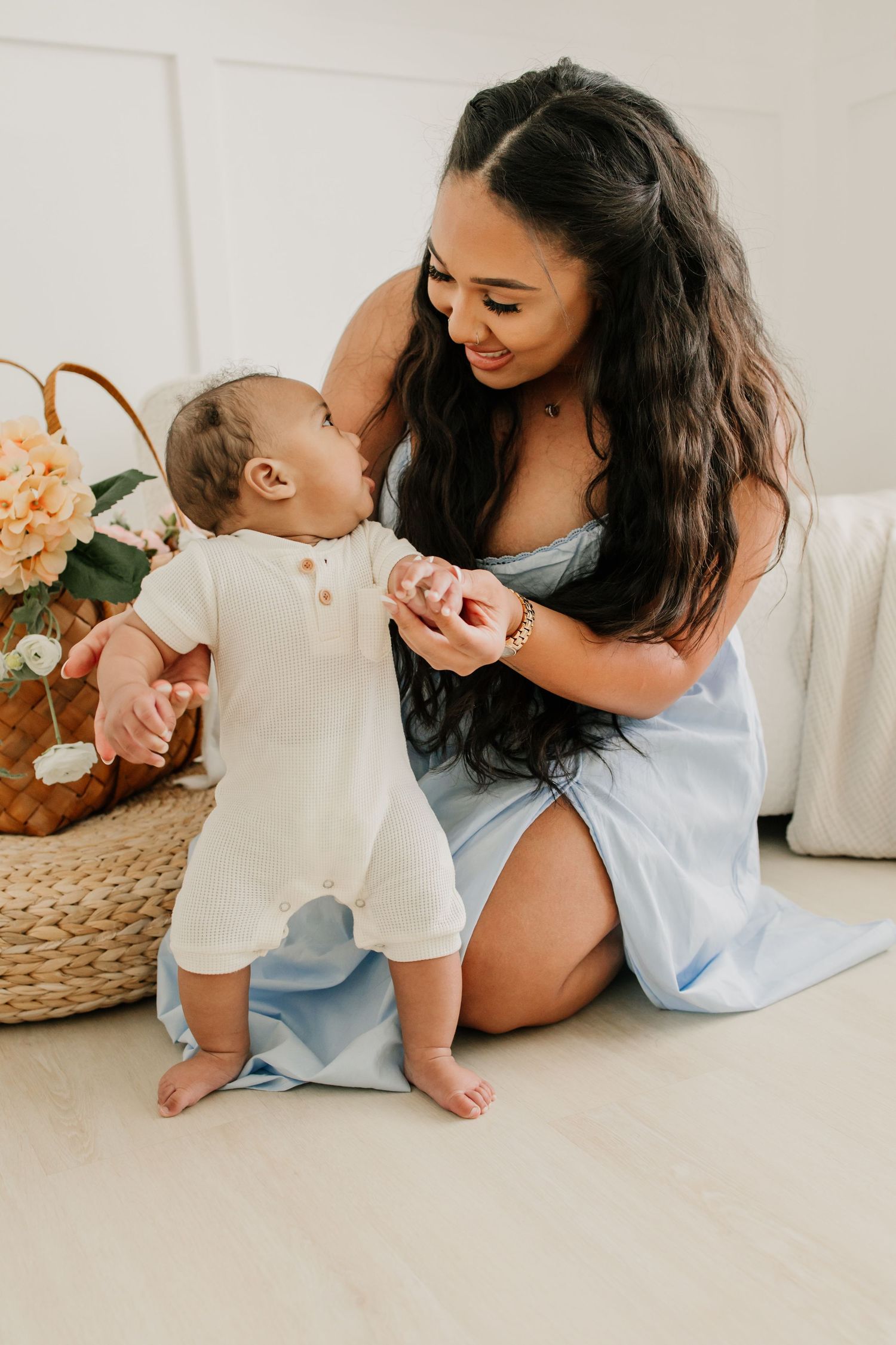 Woodbury family photographer captures smiling woman with her baby in a brightly lit studio
