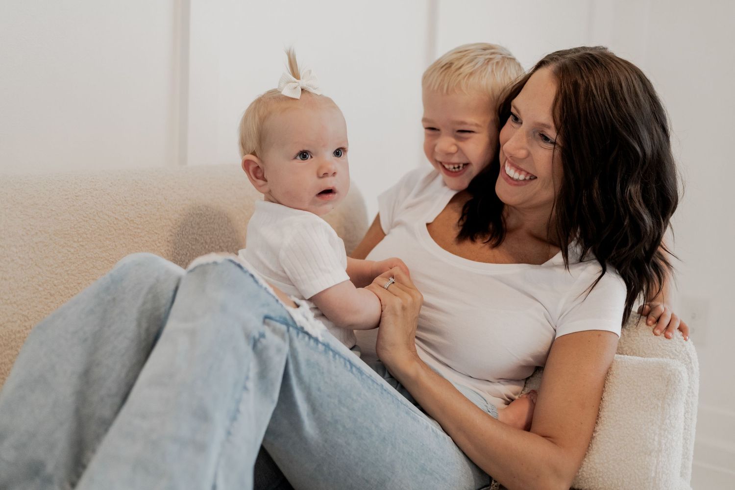 A tender moment between mom and children during a lifestyle photography mini session in a bright white room in Lakeville.