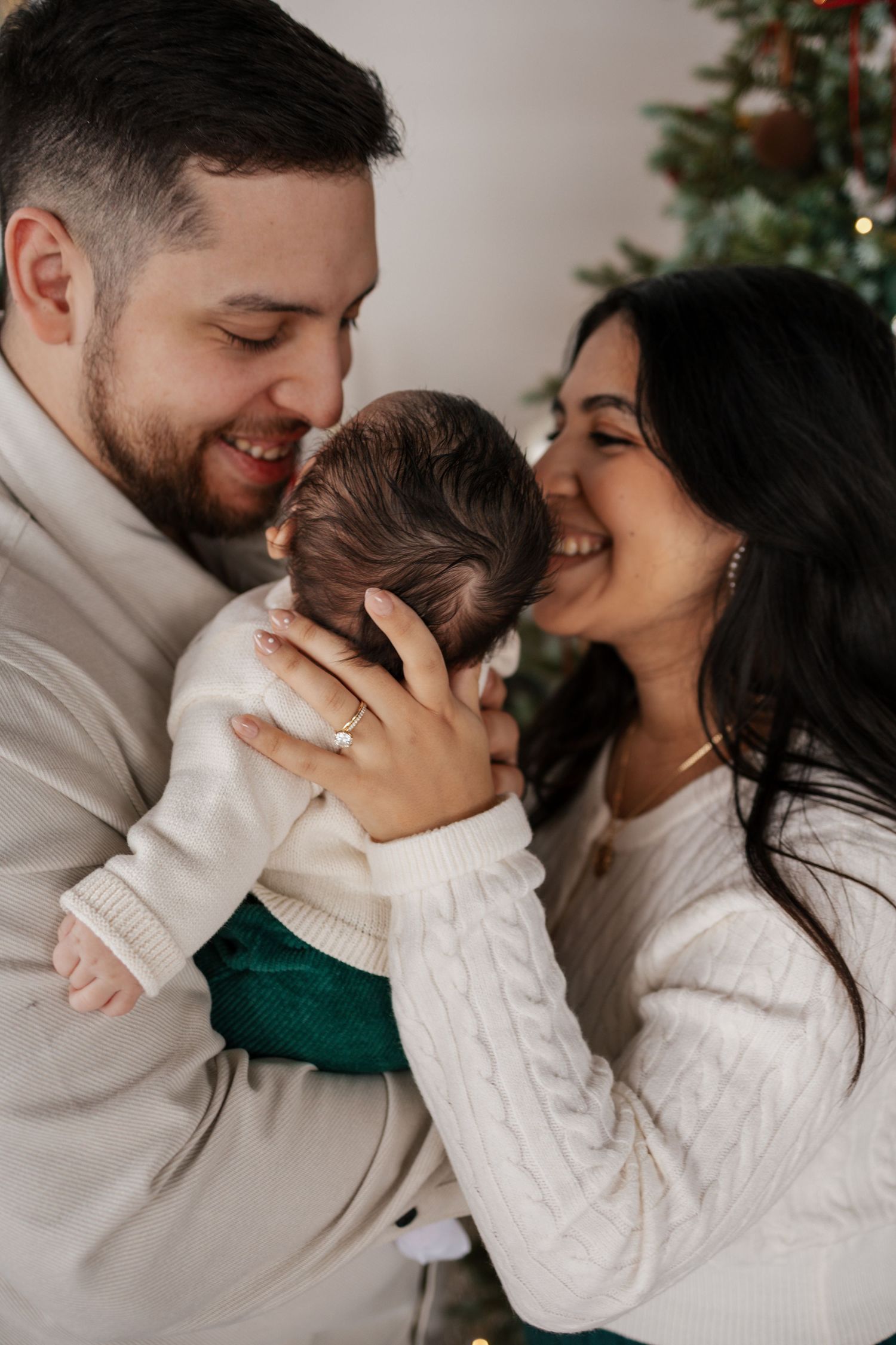 A family in white sweaters share joyful moments in a series of candid holiday portrait photos taken by Minneapolis family photographer.