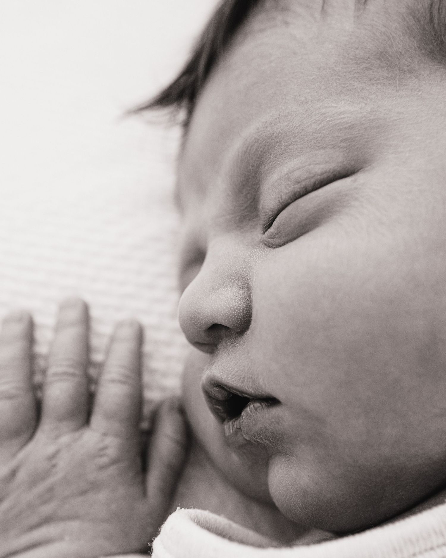 Black and white close up image of a sleeping newborn, captured naturally in Ayrshire photography studio
