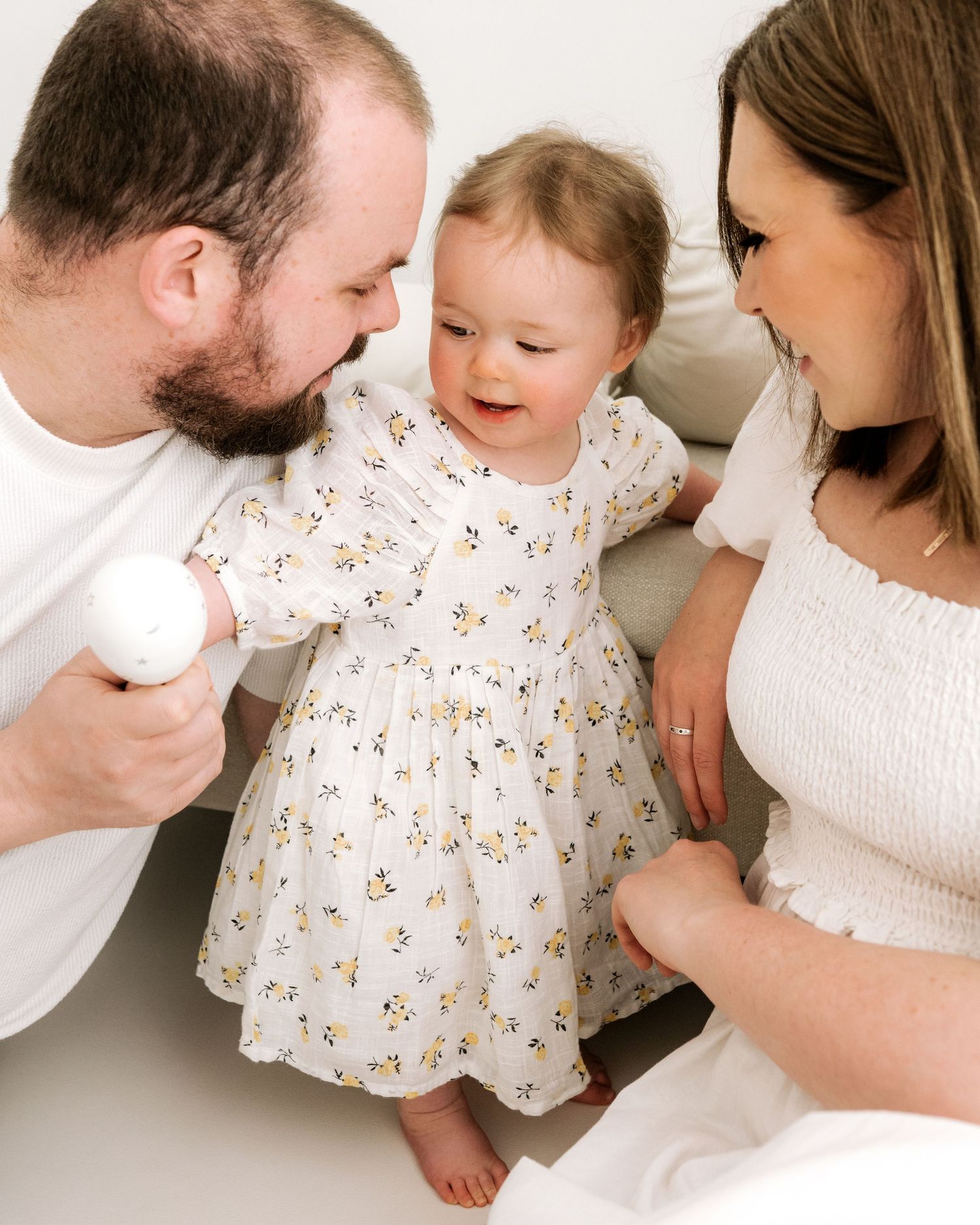 first time parents gaze lovingly at their almost 1 year old daughter