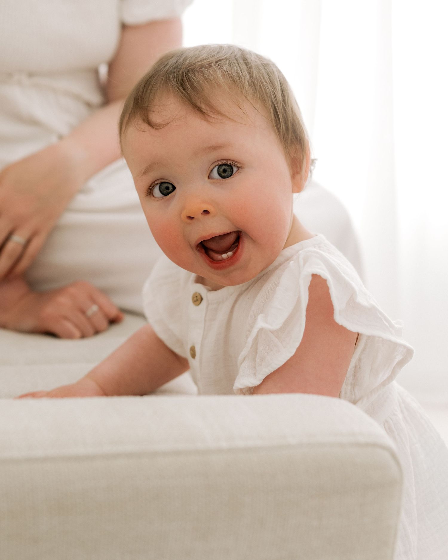 Authentic baby milestone photo in soft, neutral studio setting – her personality captured perfectly in Ayrshire photography studio