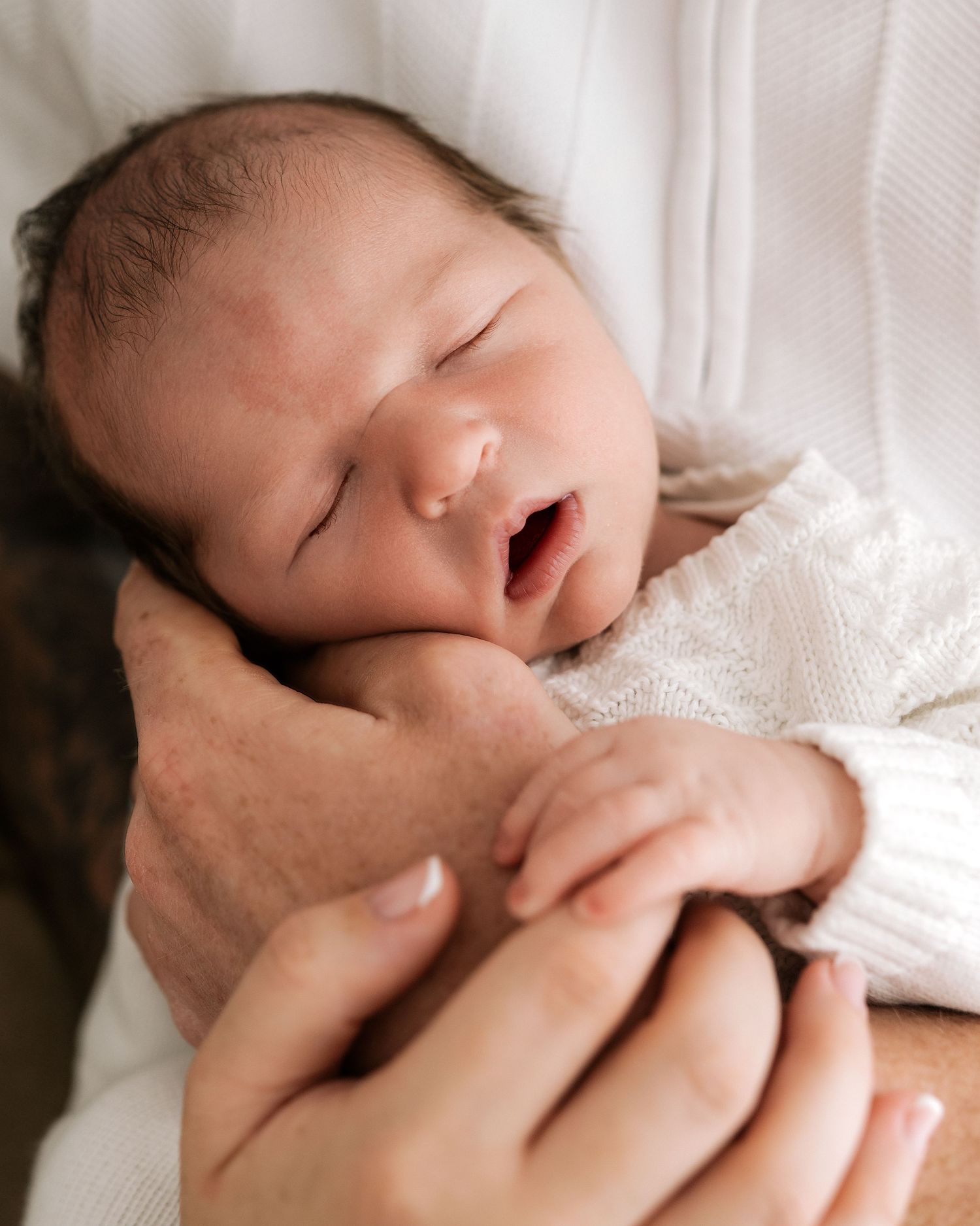 baby is sound asleep held by first time dad during his natural newborn photoshoot in Ayrshire
