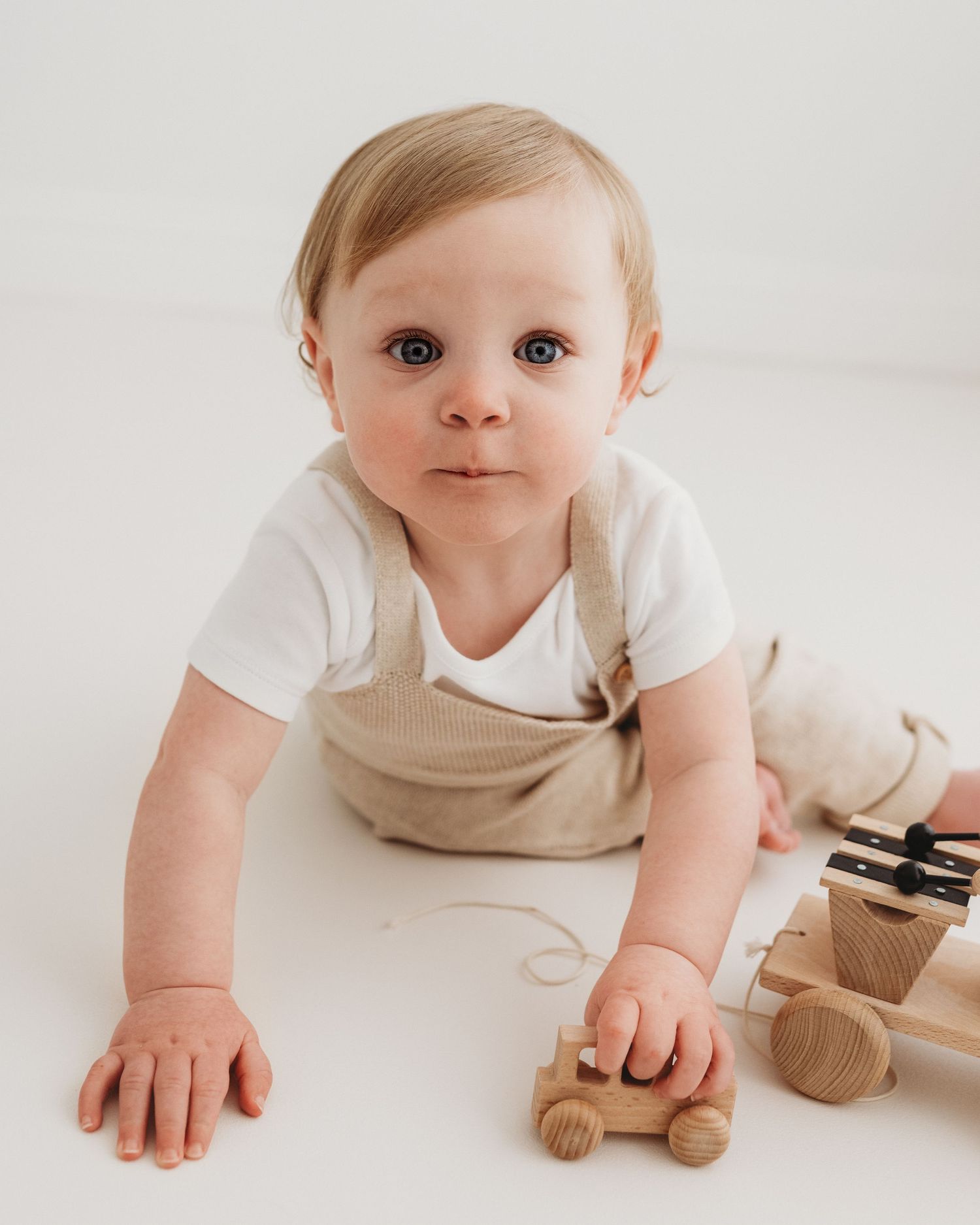 candid moment of play in 1 year olds birthday photoshoot in Faye McRae's all-white photography studio