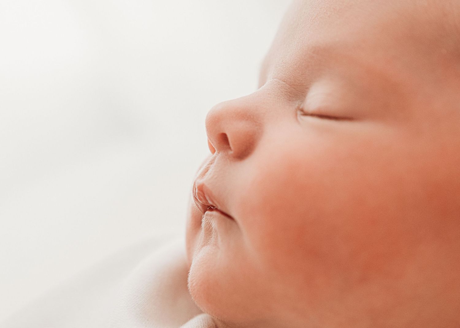 Side profile of sleeping newborn baby, naturally captured at her newborn photoshoot in Ayrshire for her new parents to remember forever