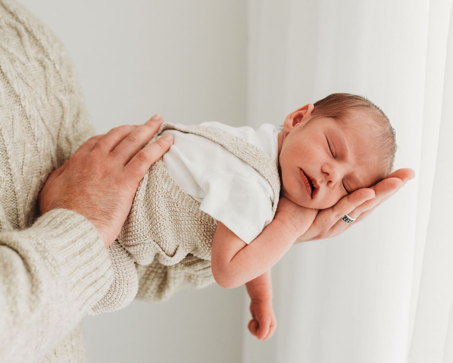 Tender moment with newborn sleeping in on dads arm, captured by South Ayrshire newborn photographer