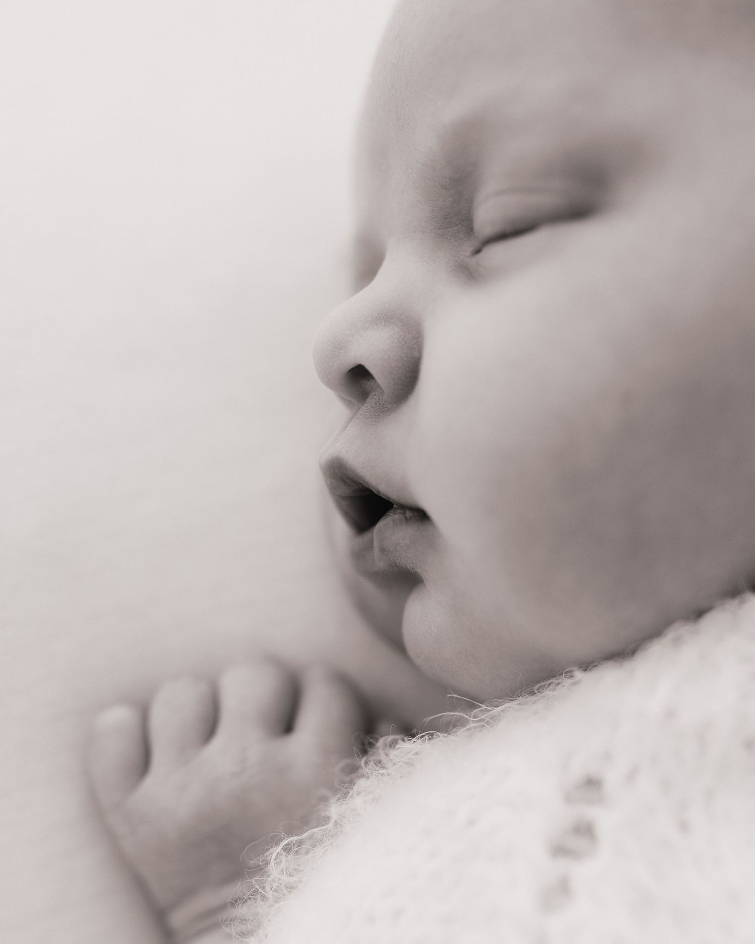 peaceful newborn baby's delicate face captured timelessly during natural newborn session in Faye McRae's Ayrshire photography studio